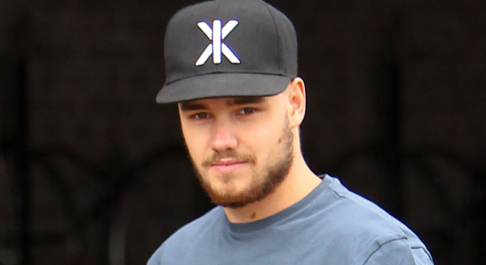 Liam Payne smiling wearing a hat