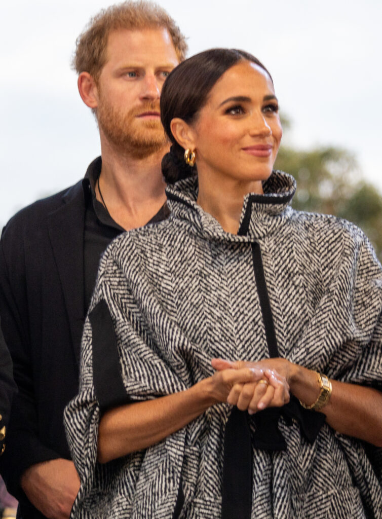 Prince Harry looks serious while stood behind Meghan Markle at One805LIVE! Festival