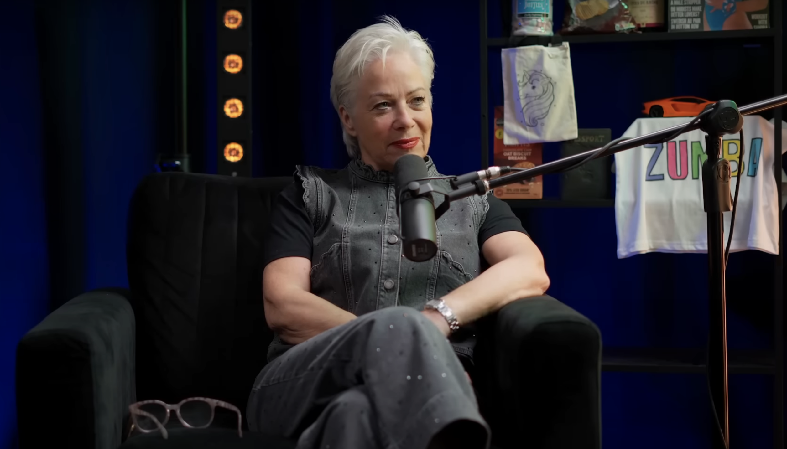 Denise Welch sitting in front of a microphone during a podcast interview