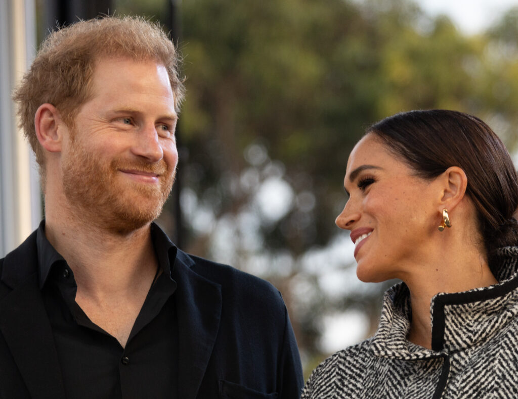 Prince Harry and Meghan markle smiling at event