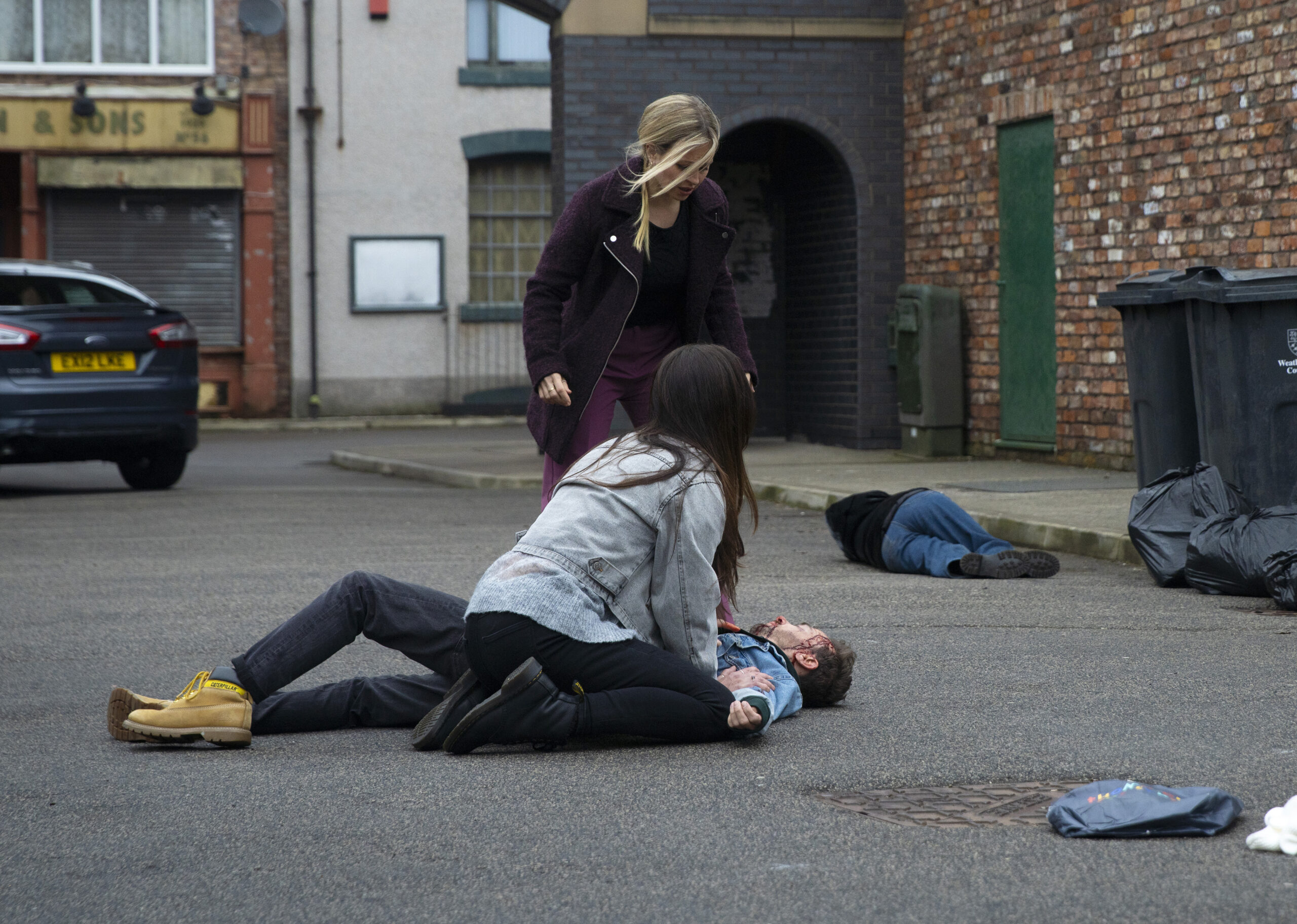 Shona and David with unconscious David in the Street