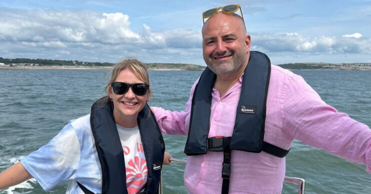 Wynne and Joanna: All At Sea. They stand on boat on the sea smiling