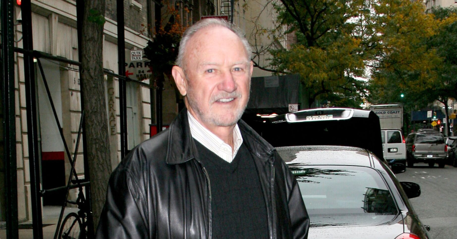 Gene Hackman wears a black leather jacket, sweater and white shirt in New York City