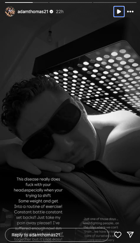 Adam Thomas under a lamp wearing glasses