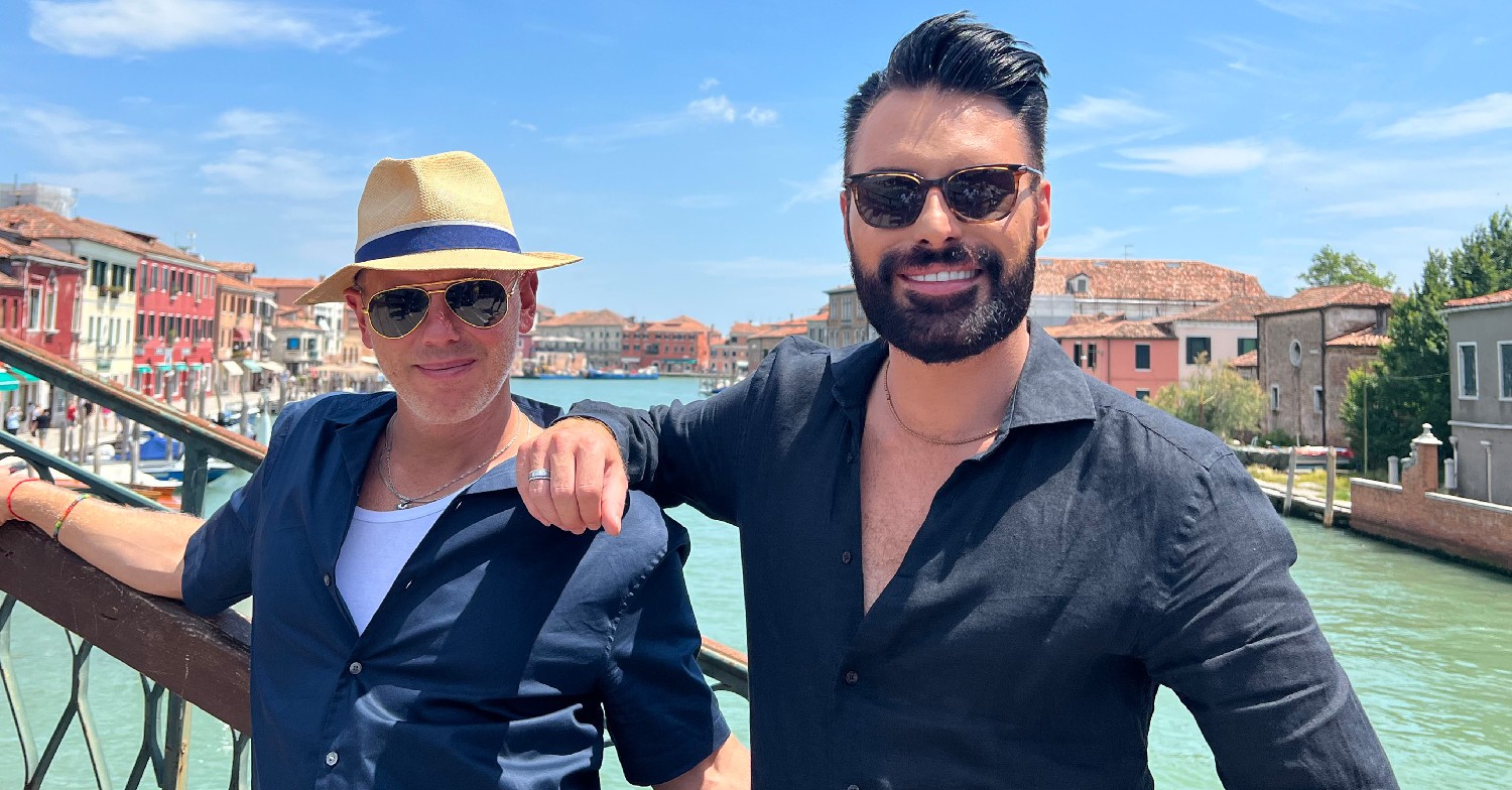 Rob Rinder and Rylan Clark smiling on a bridge in Venice