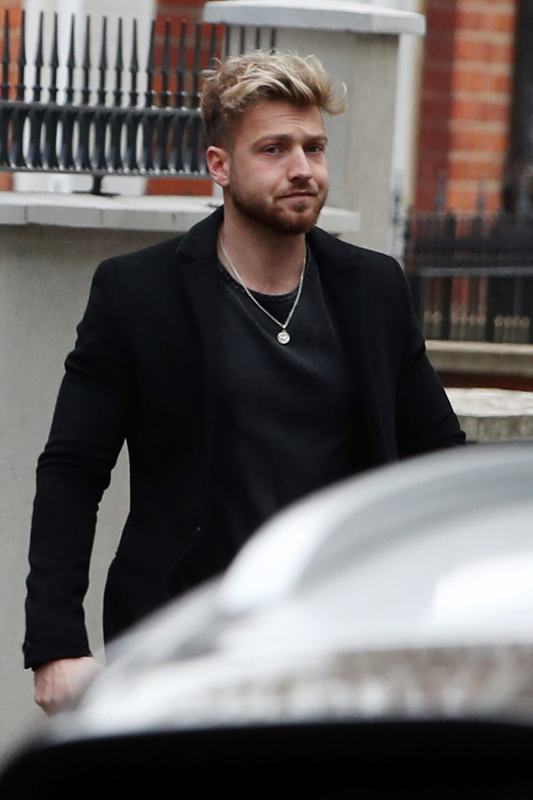 Sam Thompson looks sad as he steps outside his house 