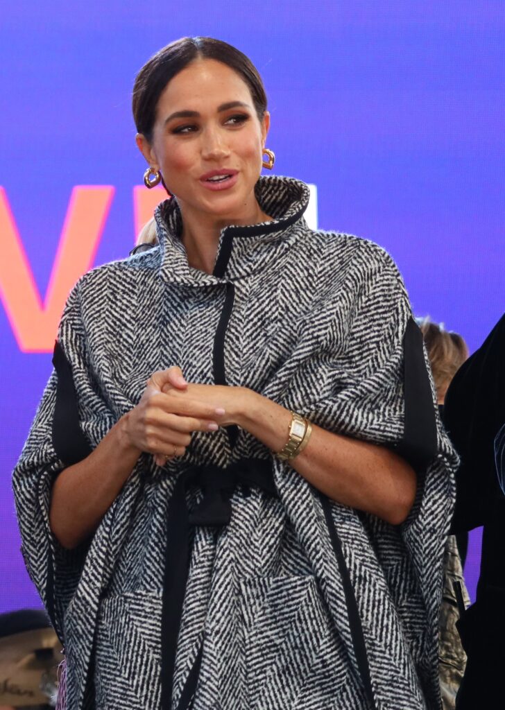 Meghan Markle talking in grey coat during event