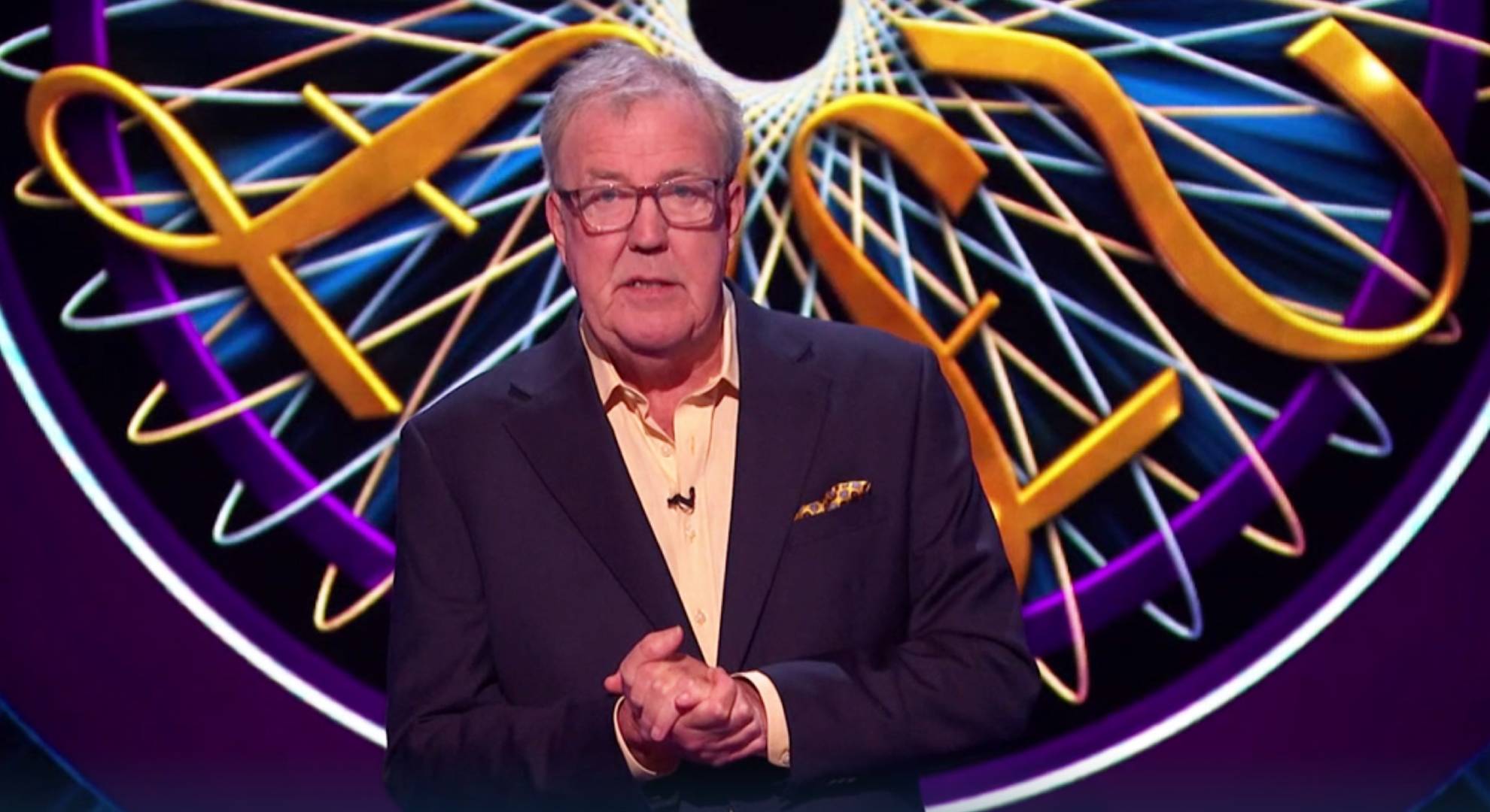 Who Wants to Be a Millionaire? host Jeremy Clarkson clasps his hands