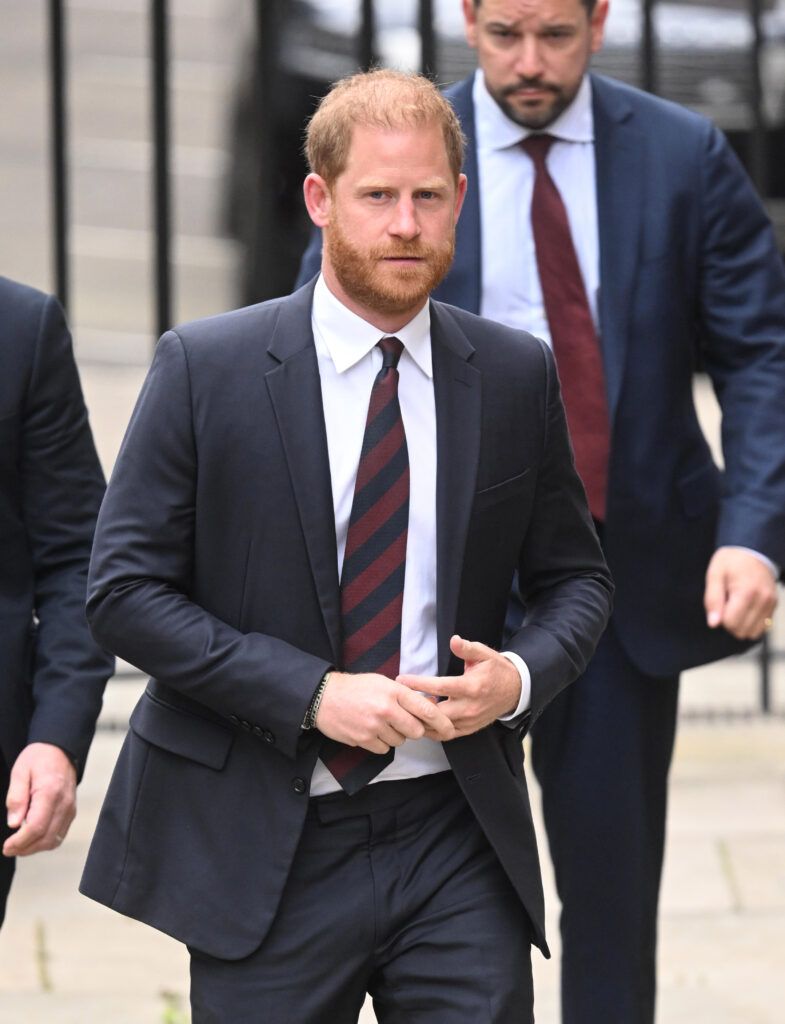 Prince Harry wearing a suit and tie walking in London