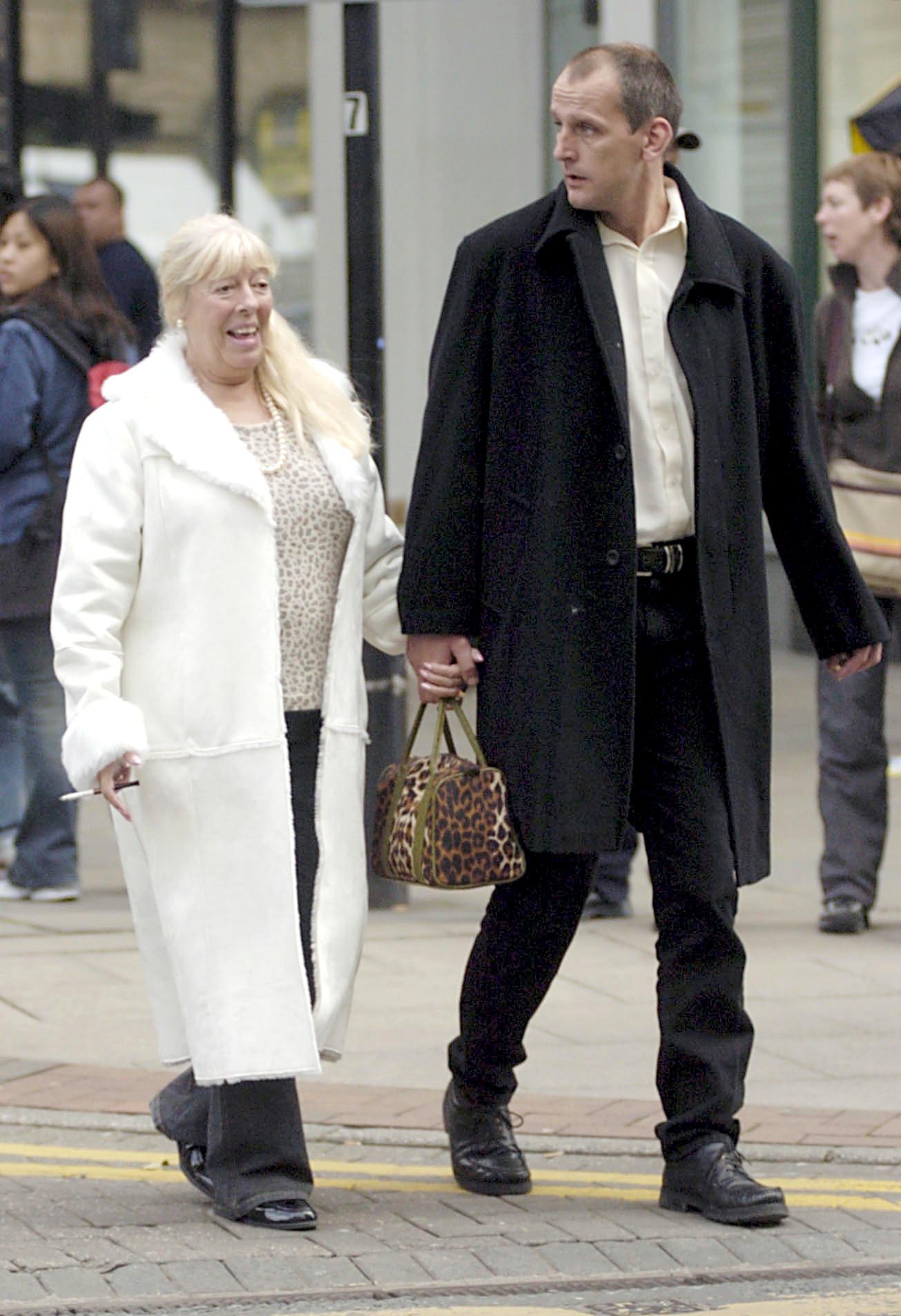 Julie Goodyear and husband Scott Brand holding hands