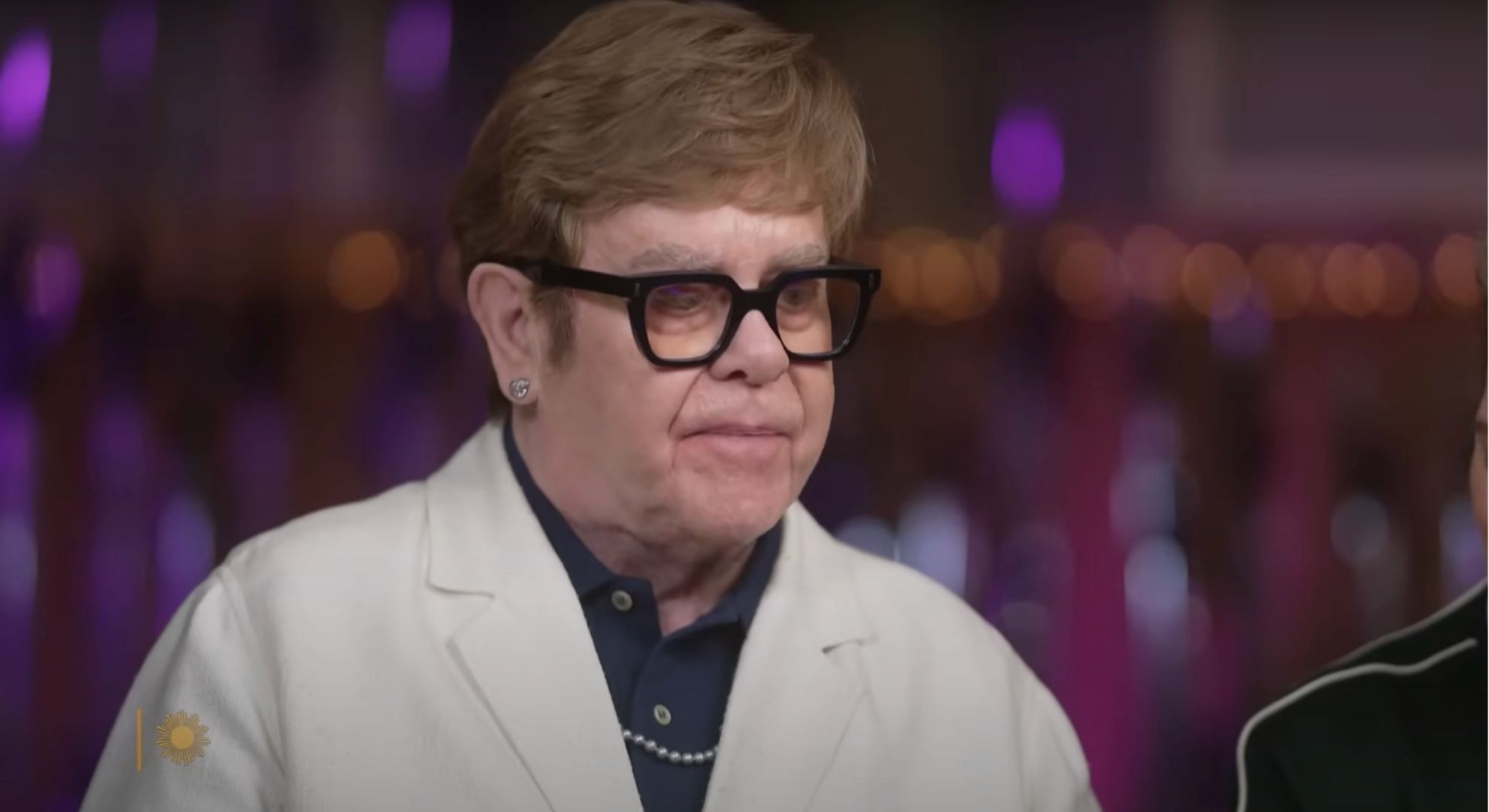 Elton John looking down in an interview