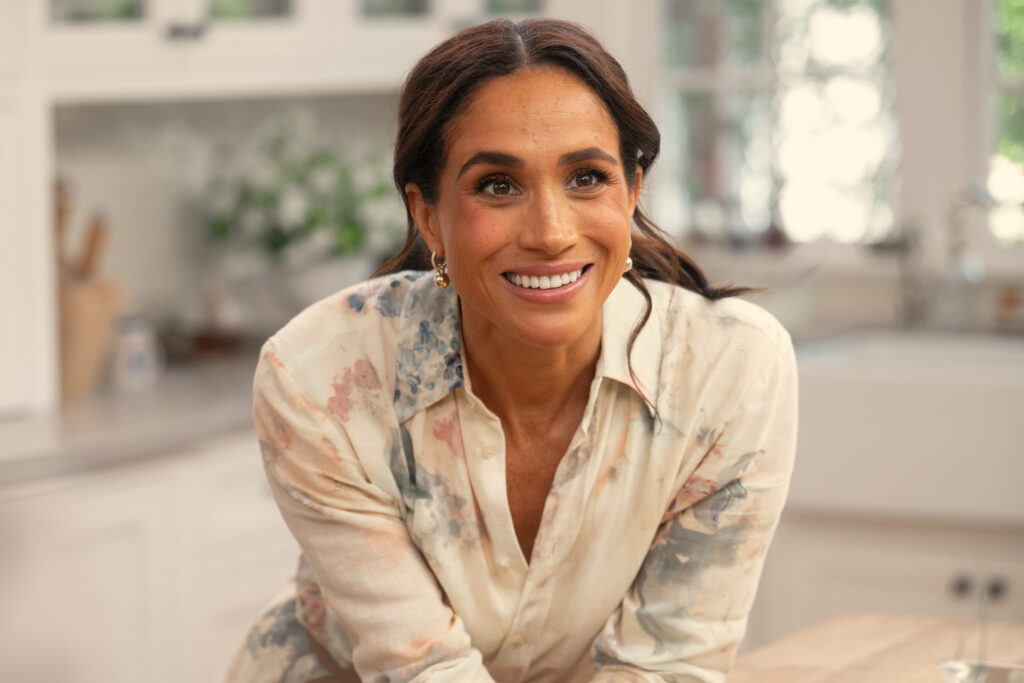 Meghan Markle smiles as she leans on the kitchen counter