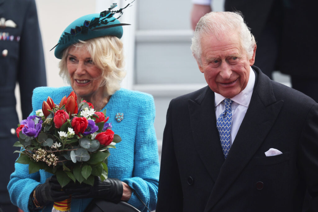 King Charles and Queen Camilla smile outside