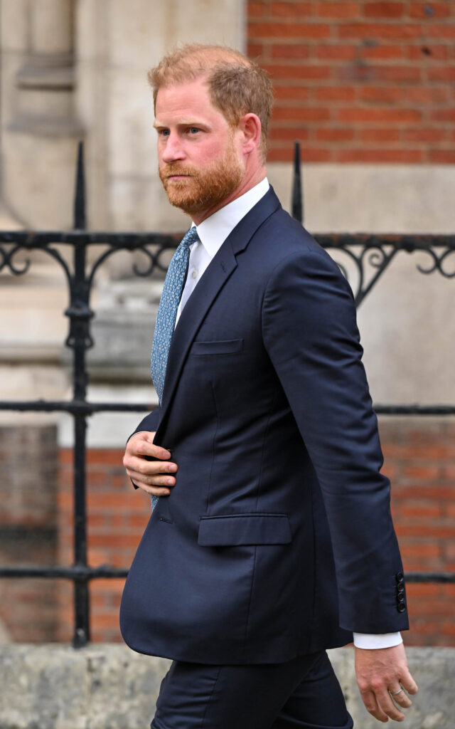 Prince Harry frowning walking in a suit