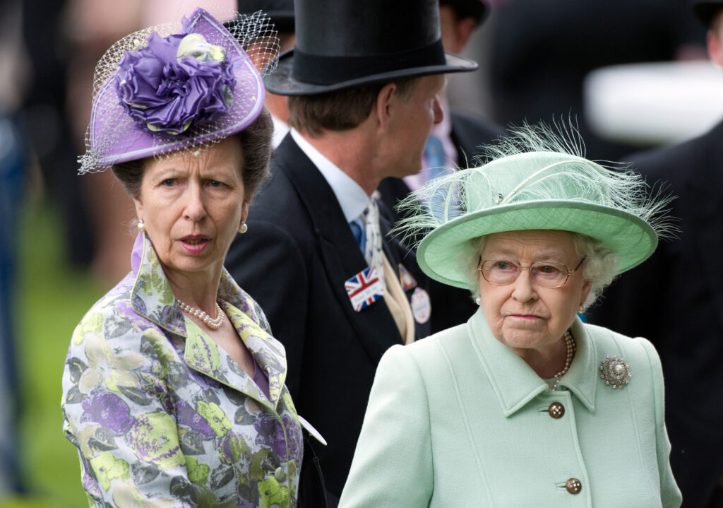 Princess Anne and Queen Elizabeth frowning side by side 