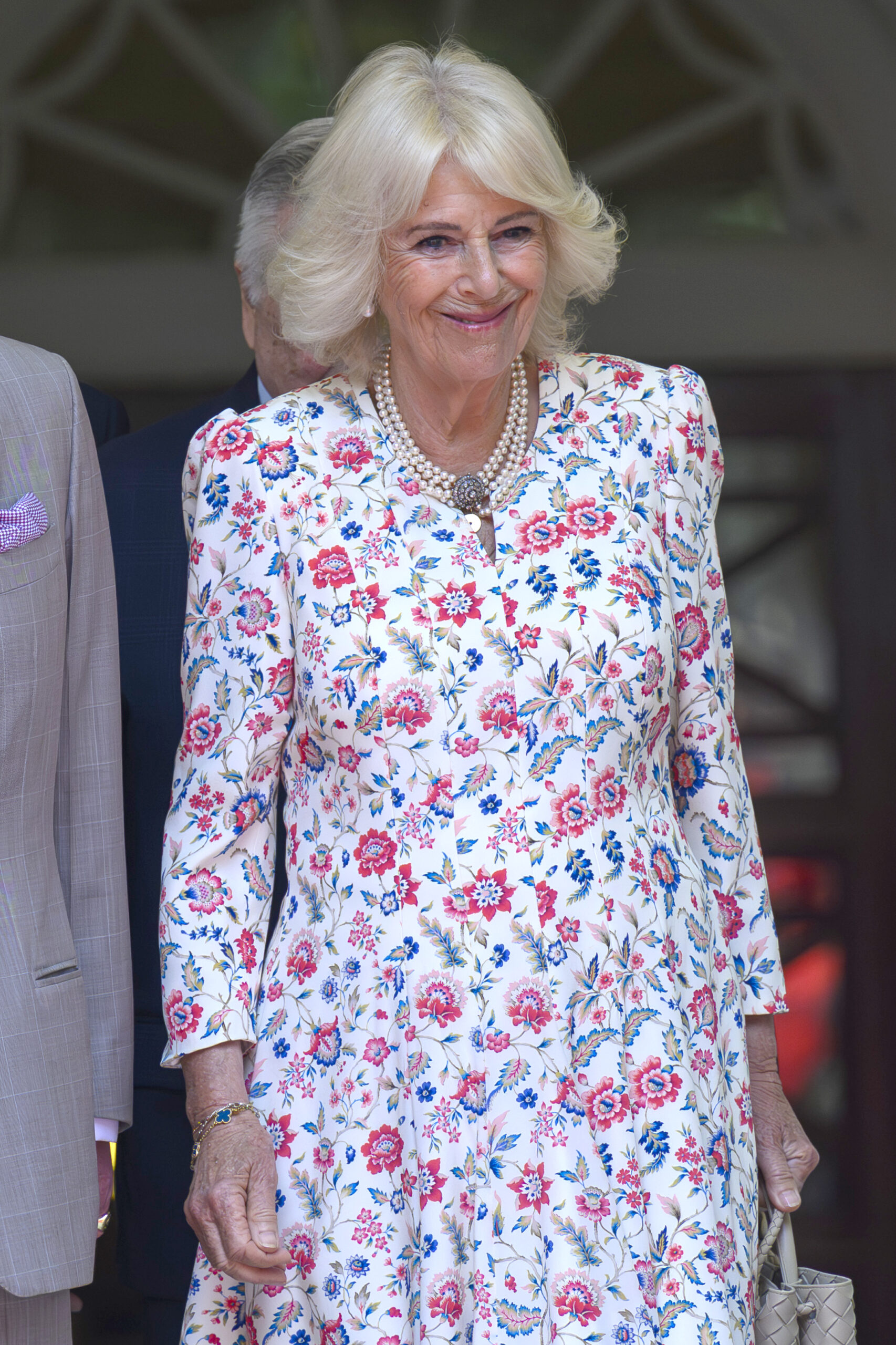 Queen Camilla smiling in floral dress during royal engagement 