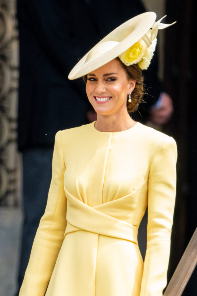Princess Kate wearing a yellow suit dress and pearl and diamond earrings