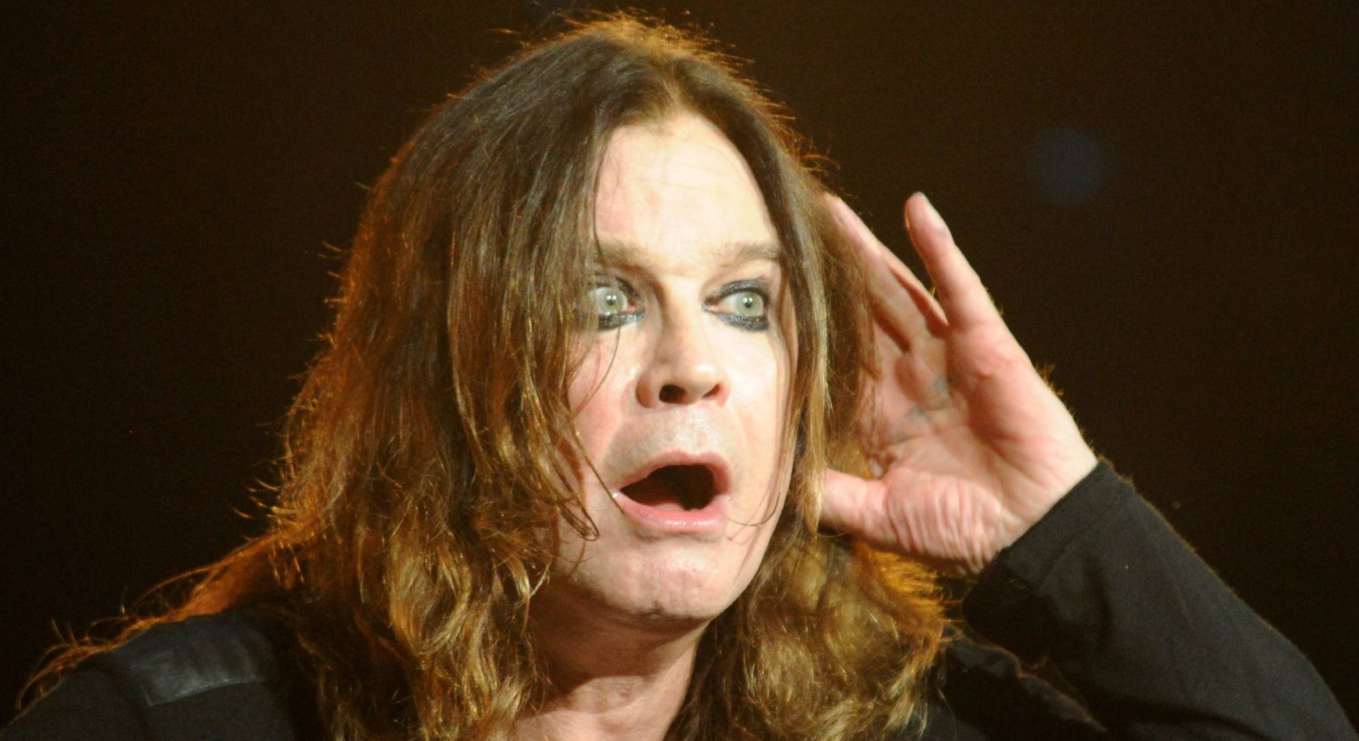 Ozzy Osbourne cups his ear