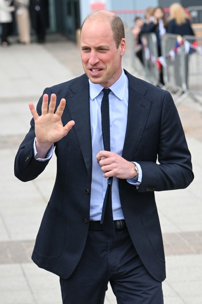 Prince William wears a black suit and blue shirt