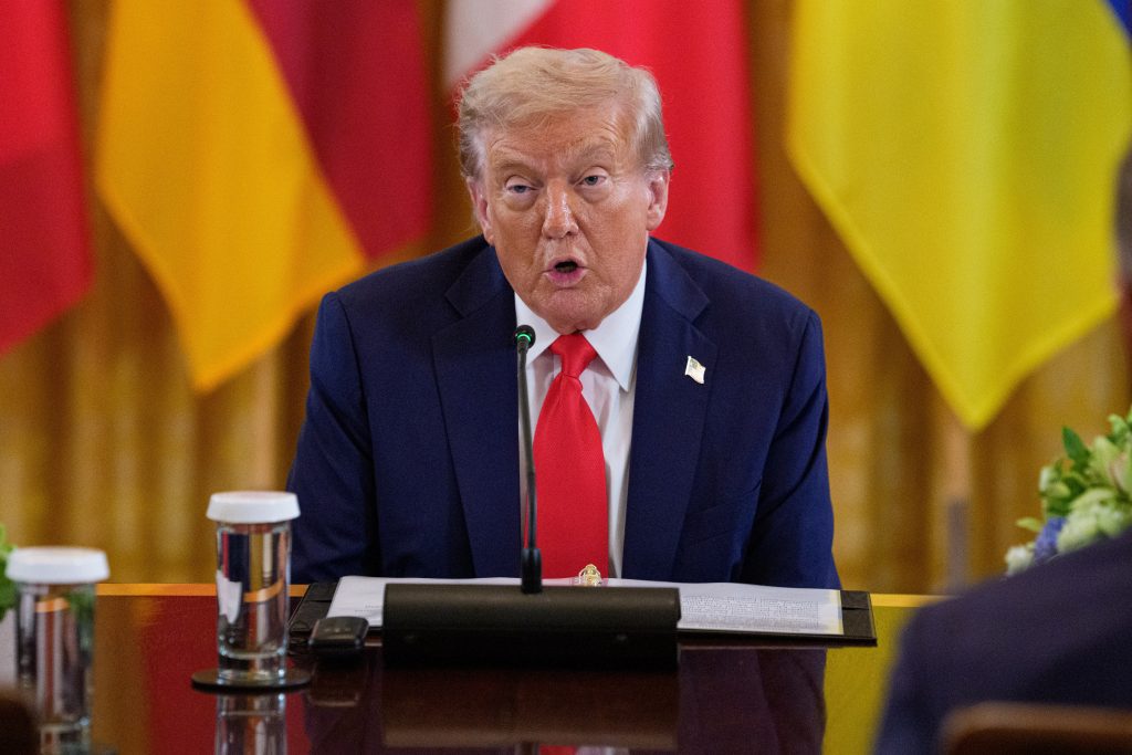 Donald Trump open-mouthed whilst talking across a table