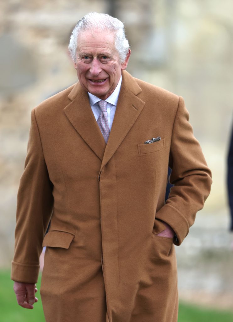 King Charles walking wearing a brown jacket