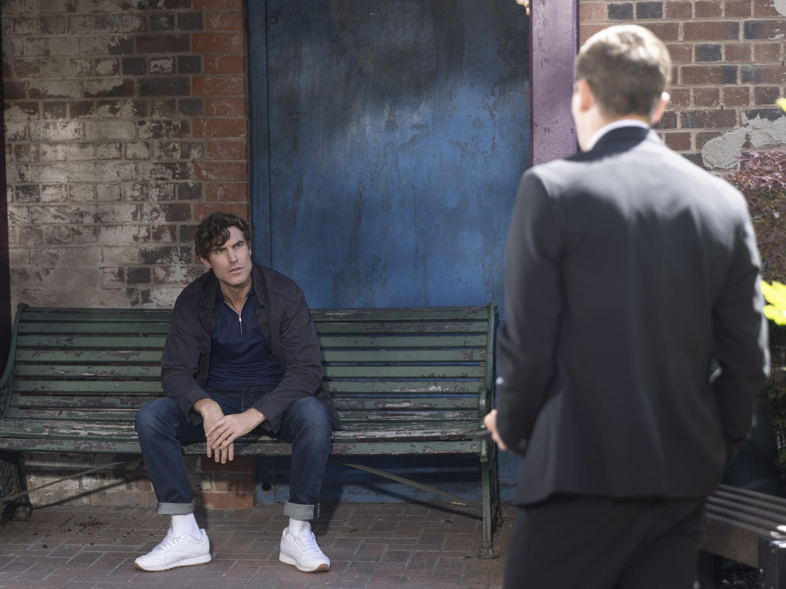 Theo on a bench in Coronation Street