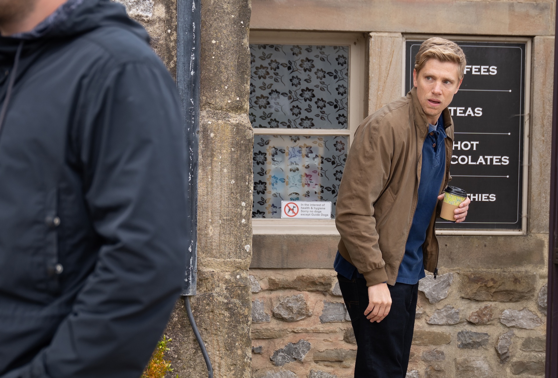 Robert looks worried outside the cafe