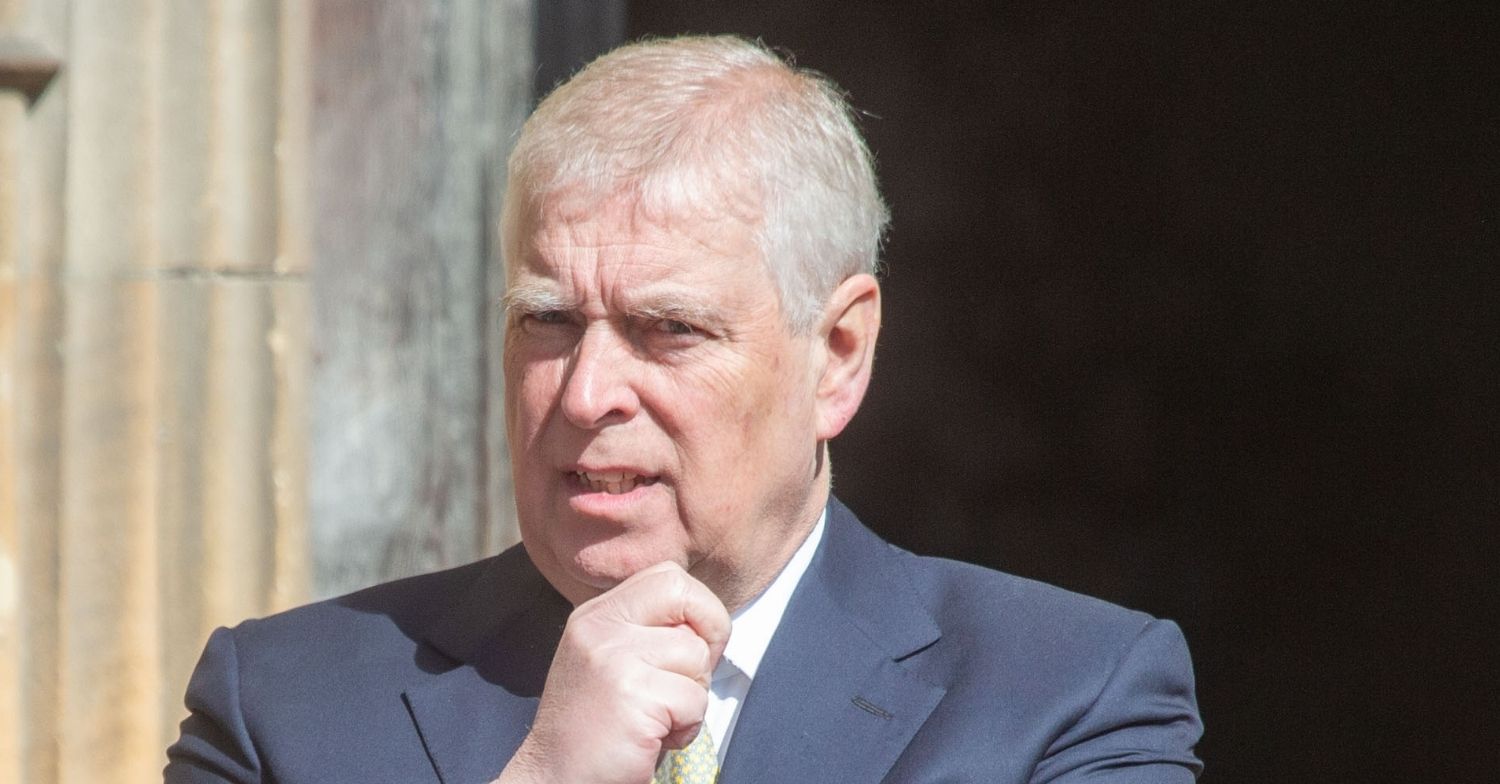 Prince Andrew with his hand on his chin in suit