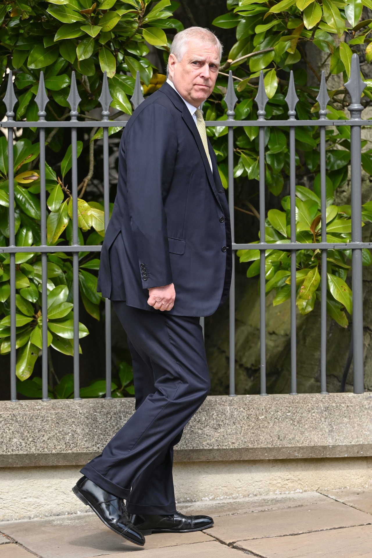 Prince Andrew walking out in public looking at camera