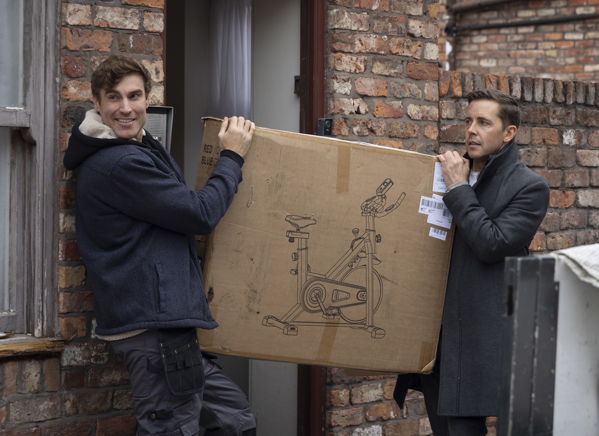 Theo and Todd holding exercise bike