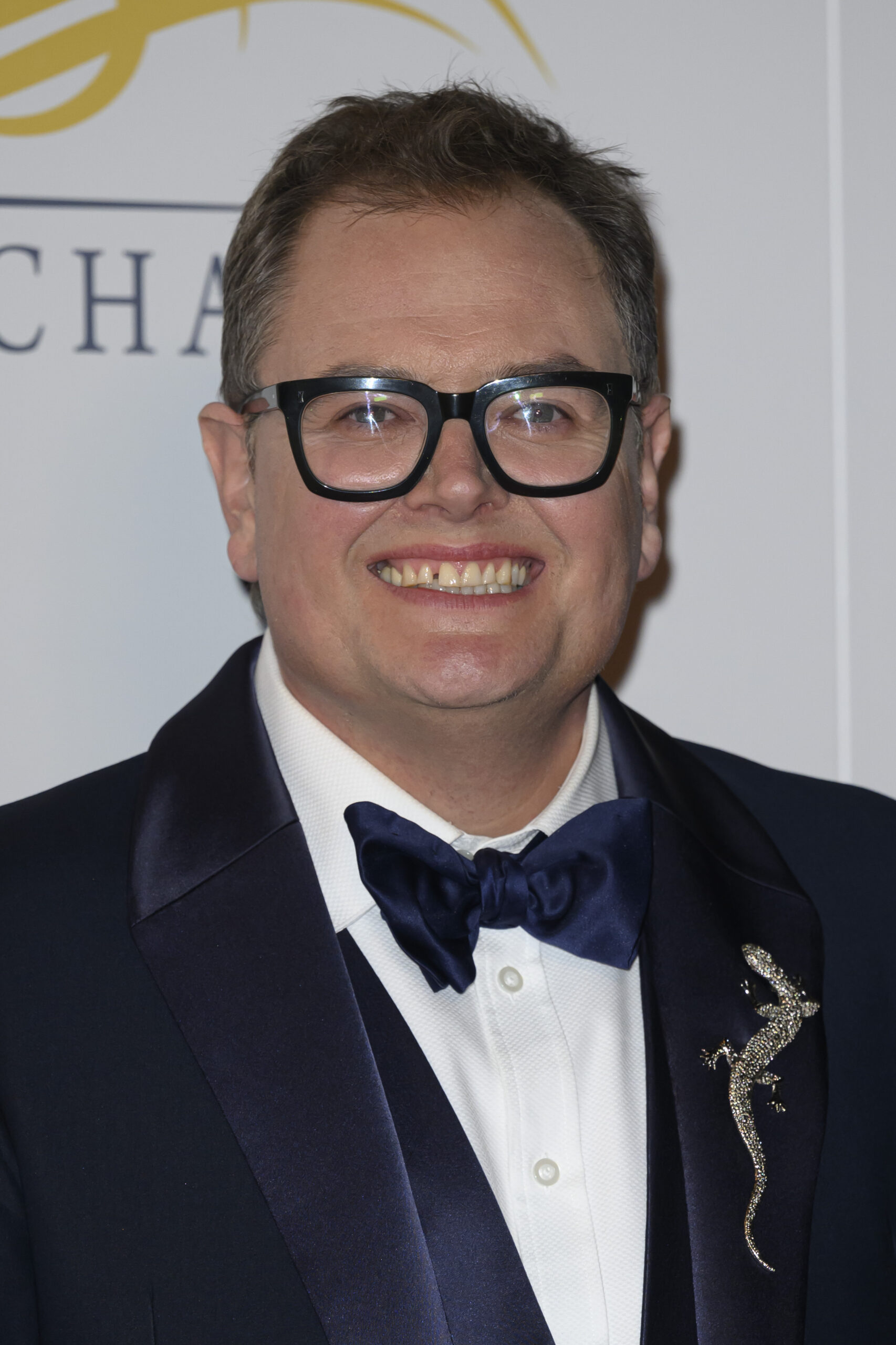 Alan Carr smiling in a tuxedo 
