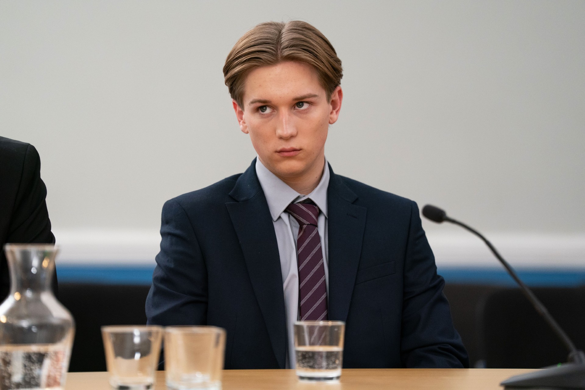 Joel in a suit and sitting in court 