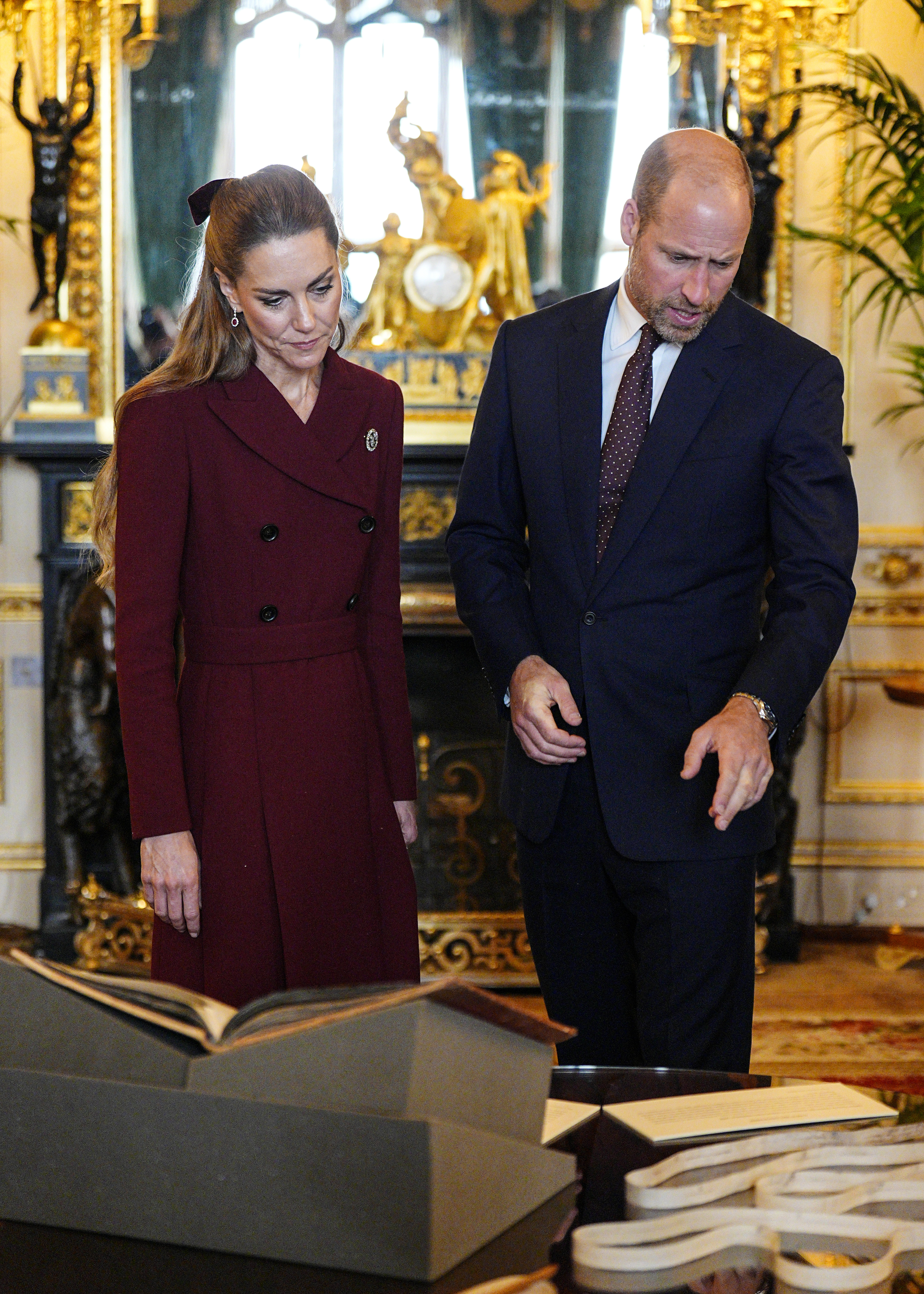 Princess Kate and Prince William looking down and reading