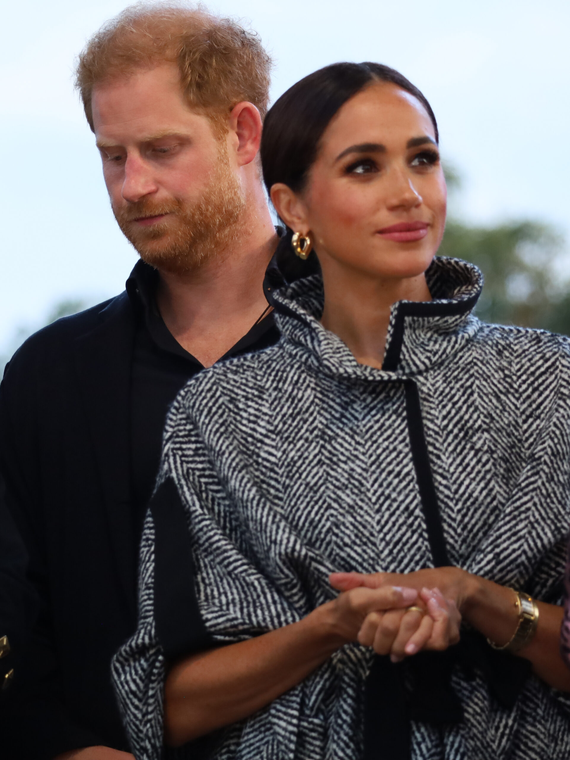 Prince Harry looking away next to Meghan Markle