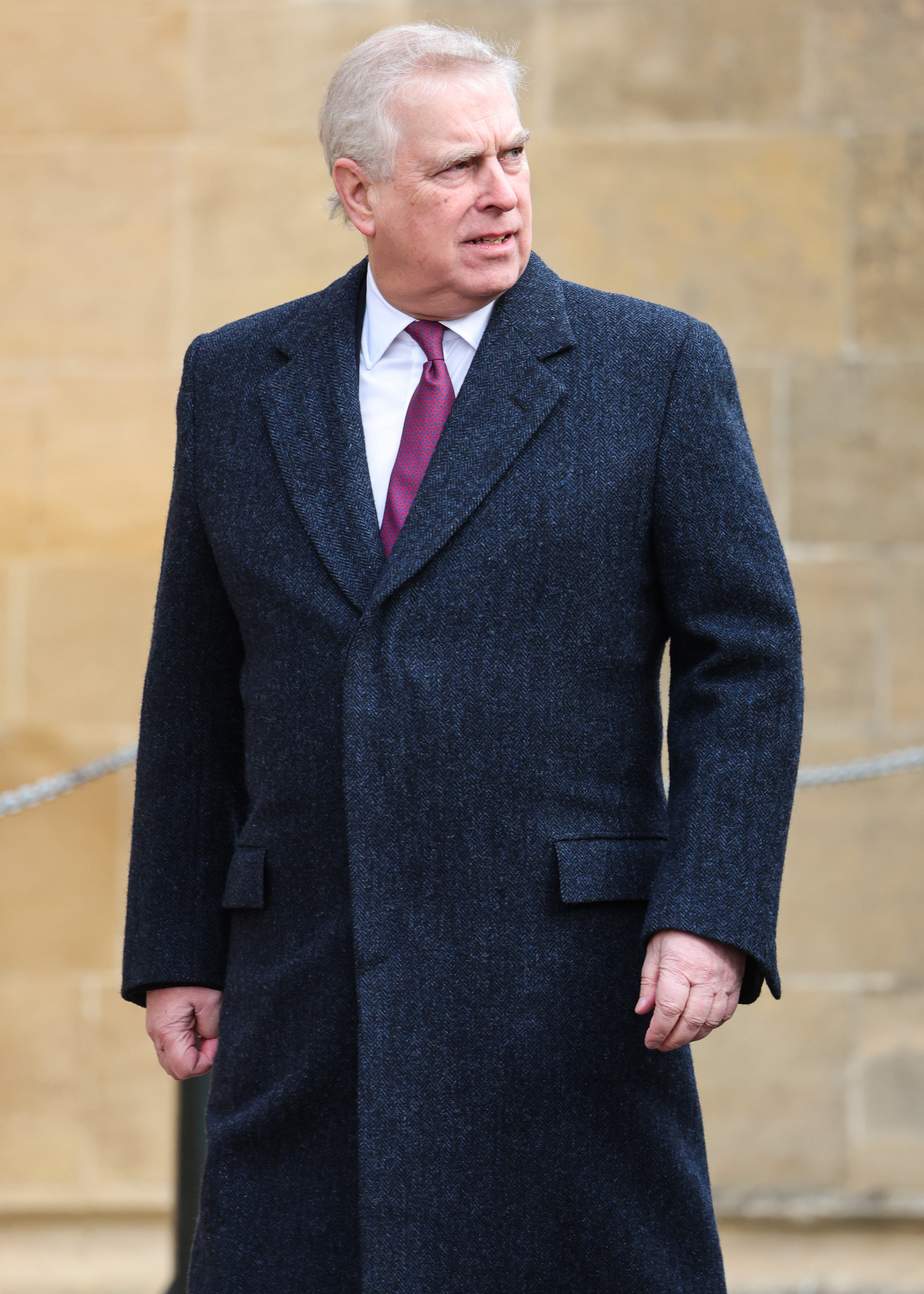 Andrew Mountbatten-Windsor walking with a serious expression