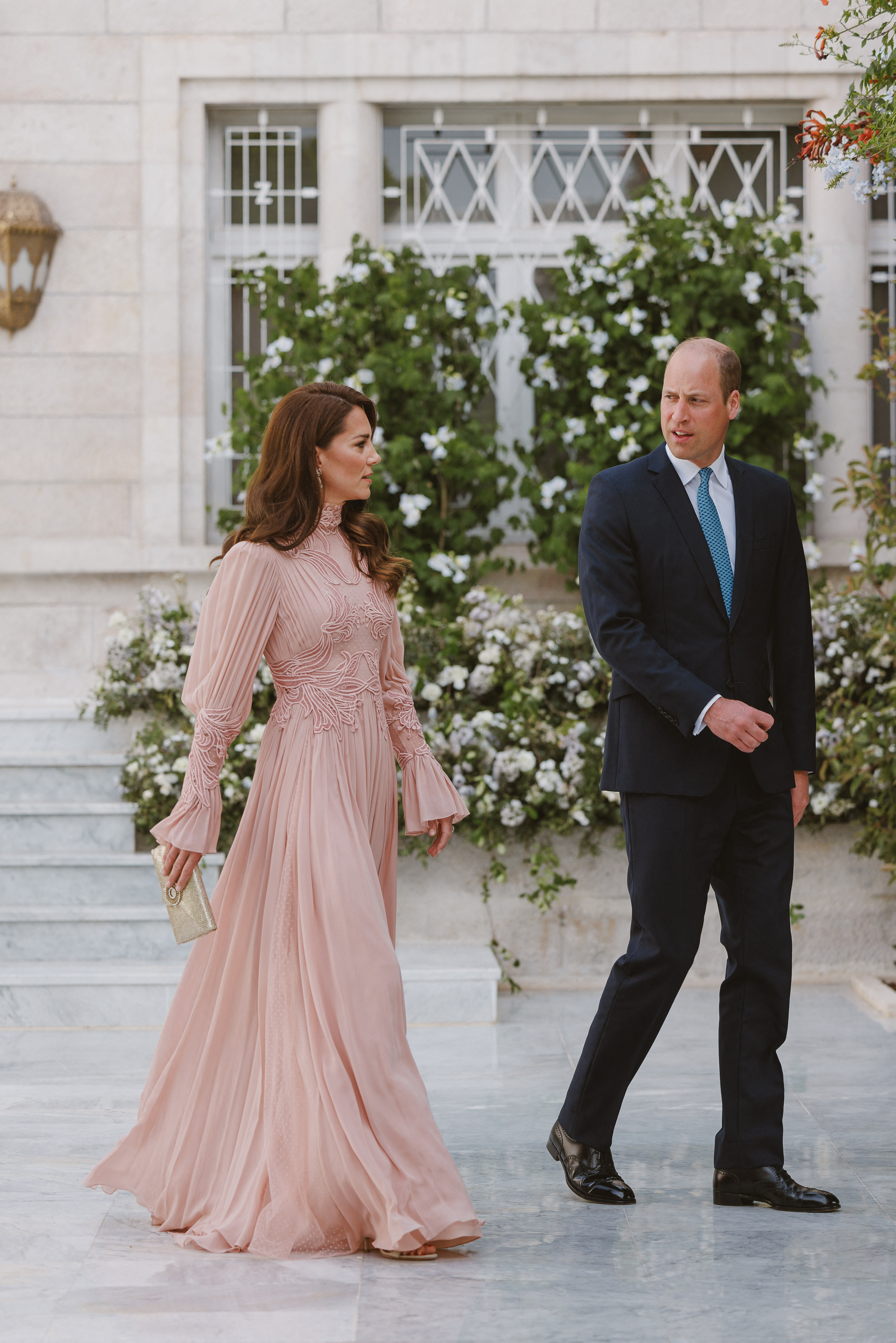 Princess Kate in a long pale pink, long-sleeve gown, walking beside Prince William