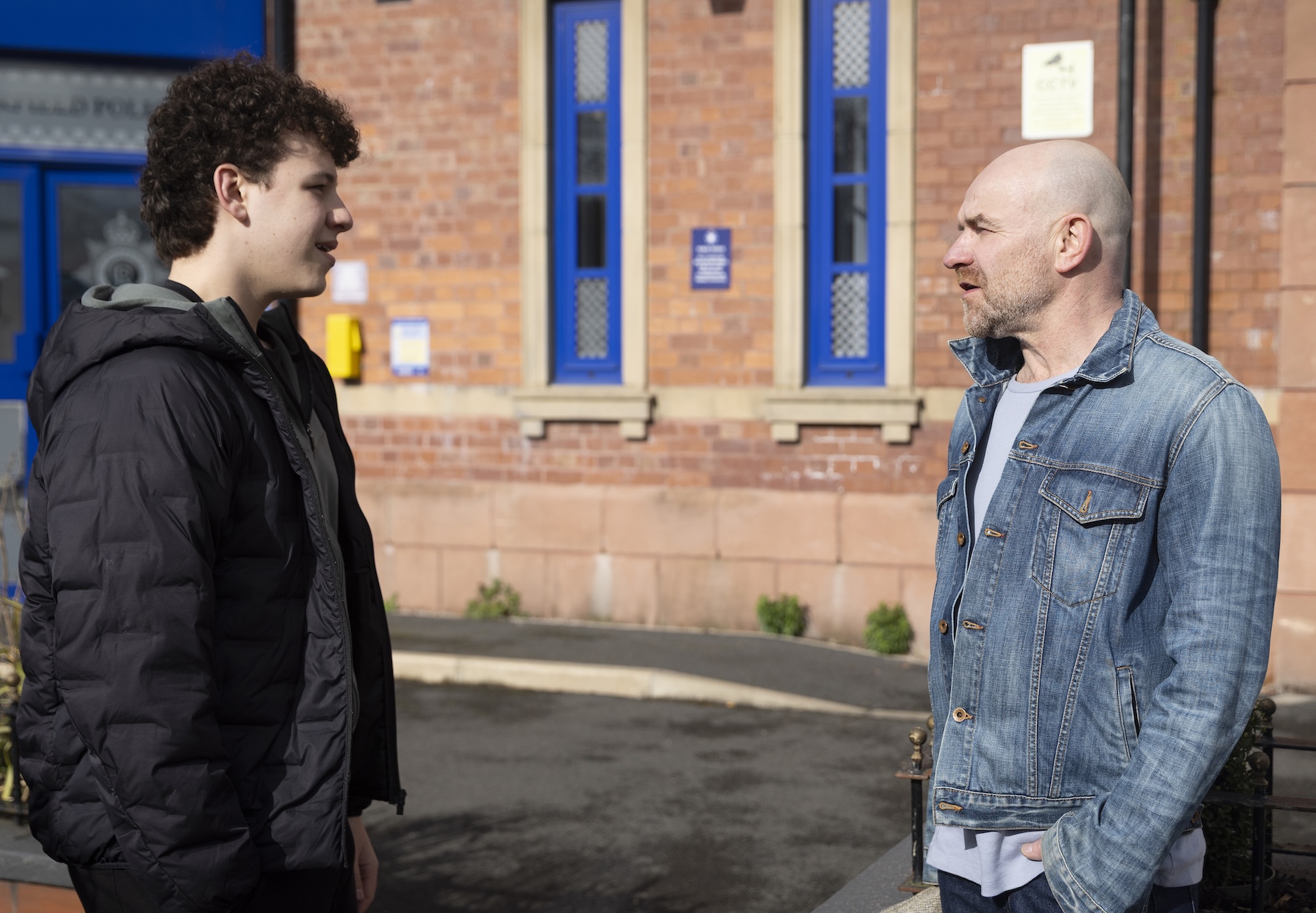 Will and Tim talking outside the police station 