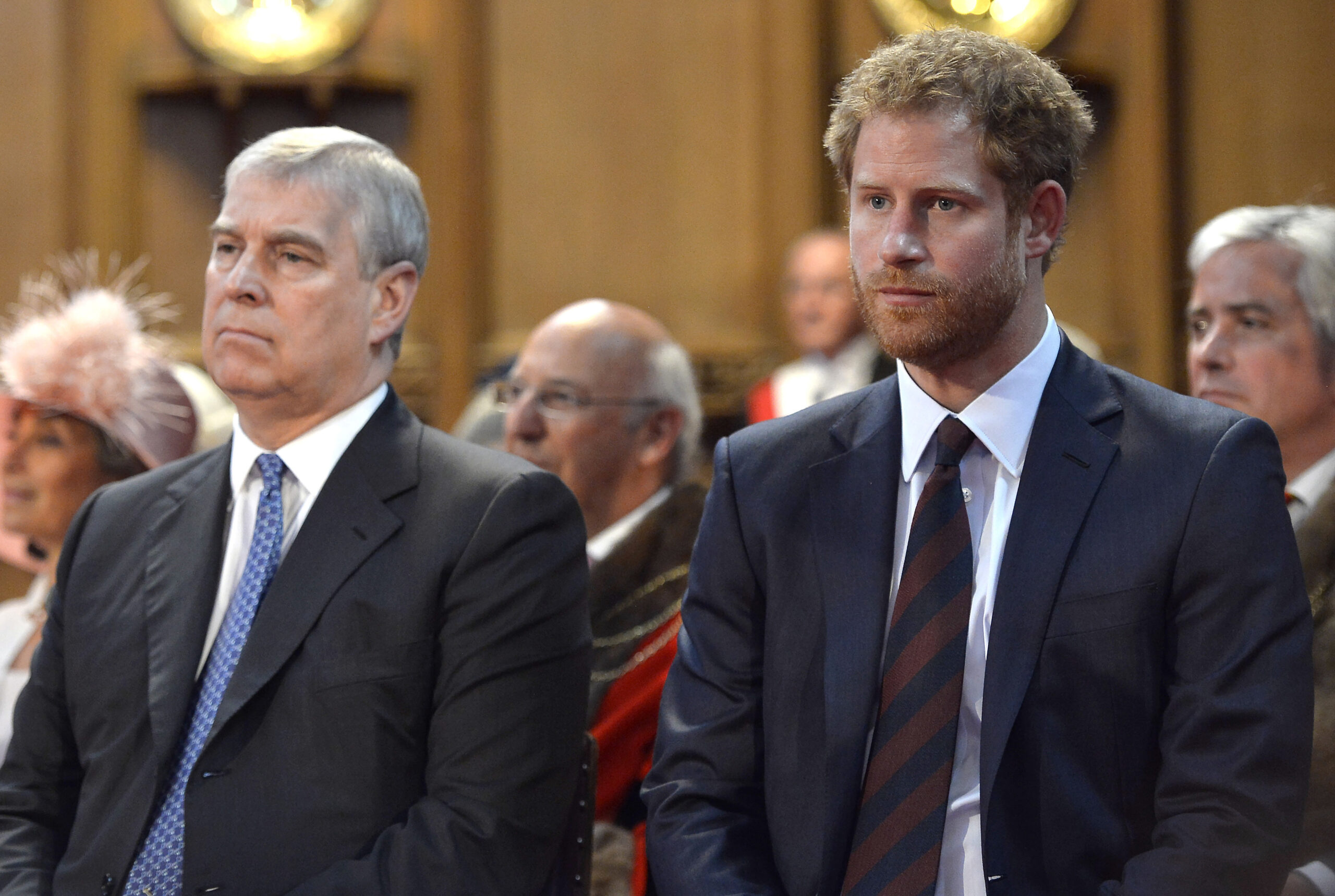 Andrew Mountbatten-Windsor and Prince Harry sat beside each other, frowning