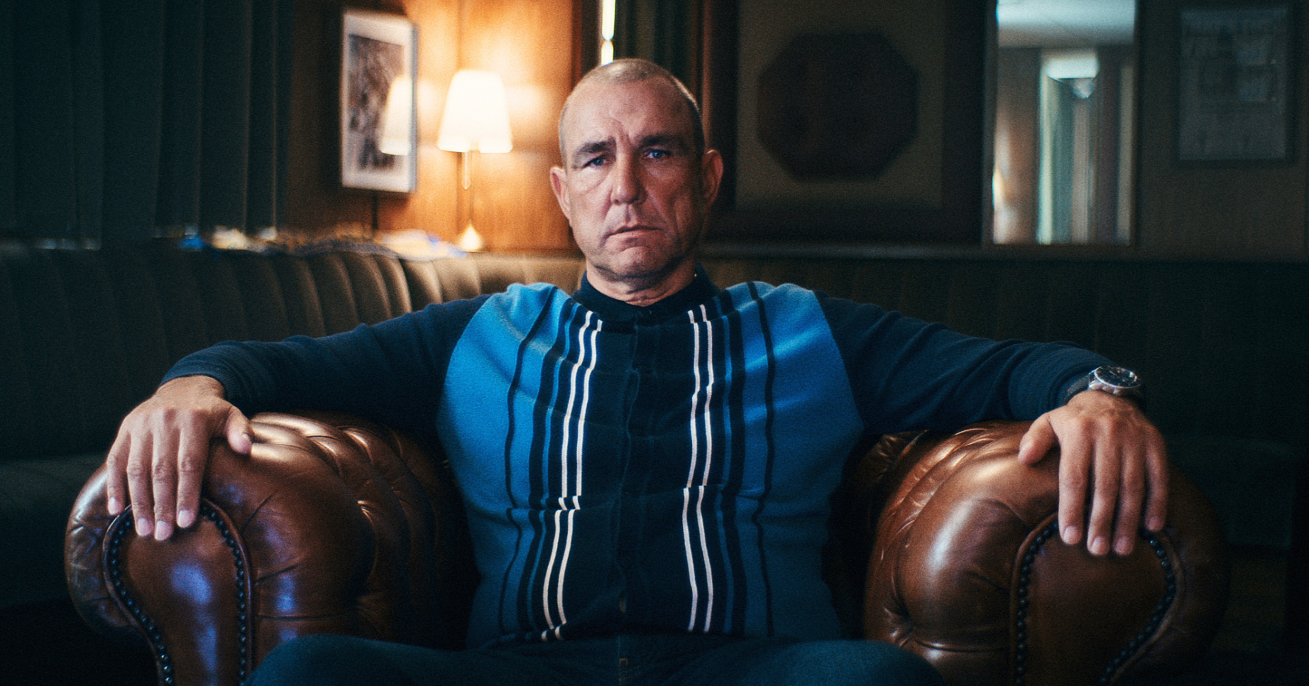 Vinnie Jones sits in a leather chair