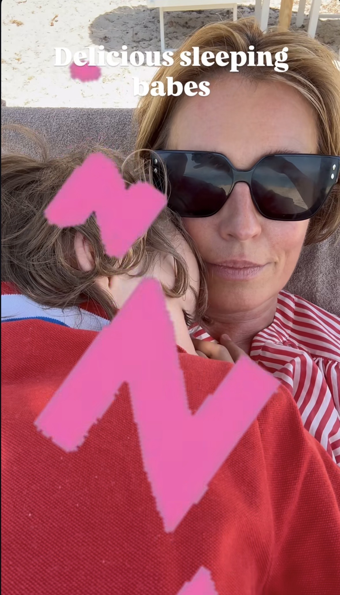 Cat Deeley on beach with son resting on her.