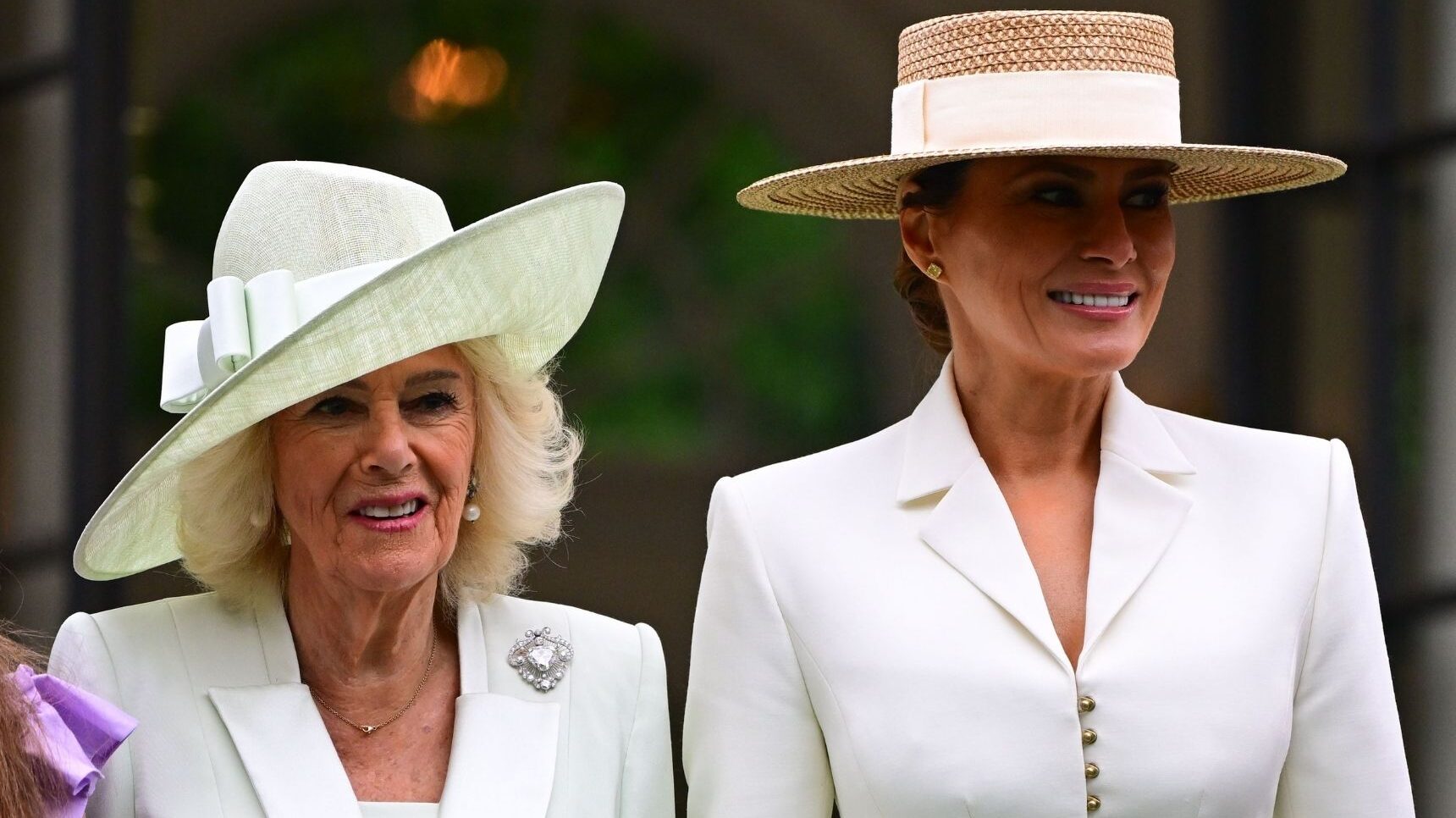 Queen Camilla and Melania Trump smiling, both wearing white