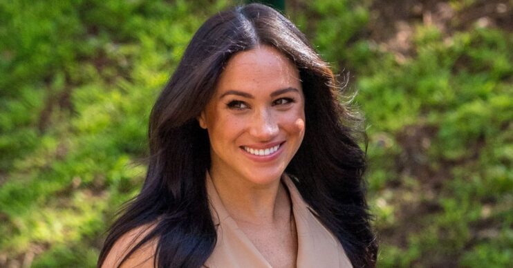 Meghan Markle smiling in beige dress