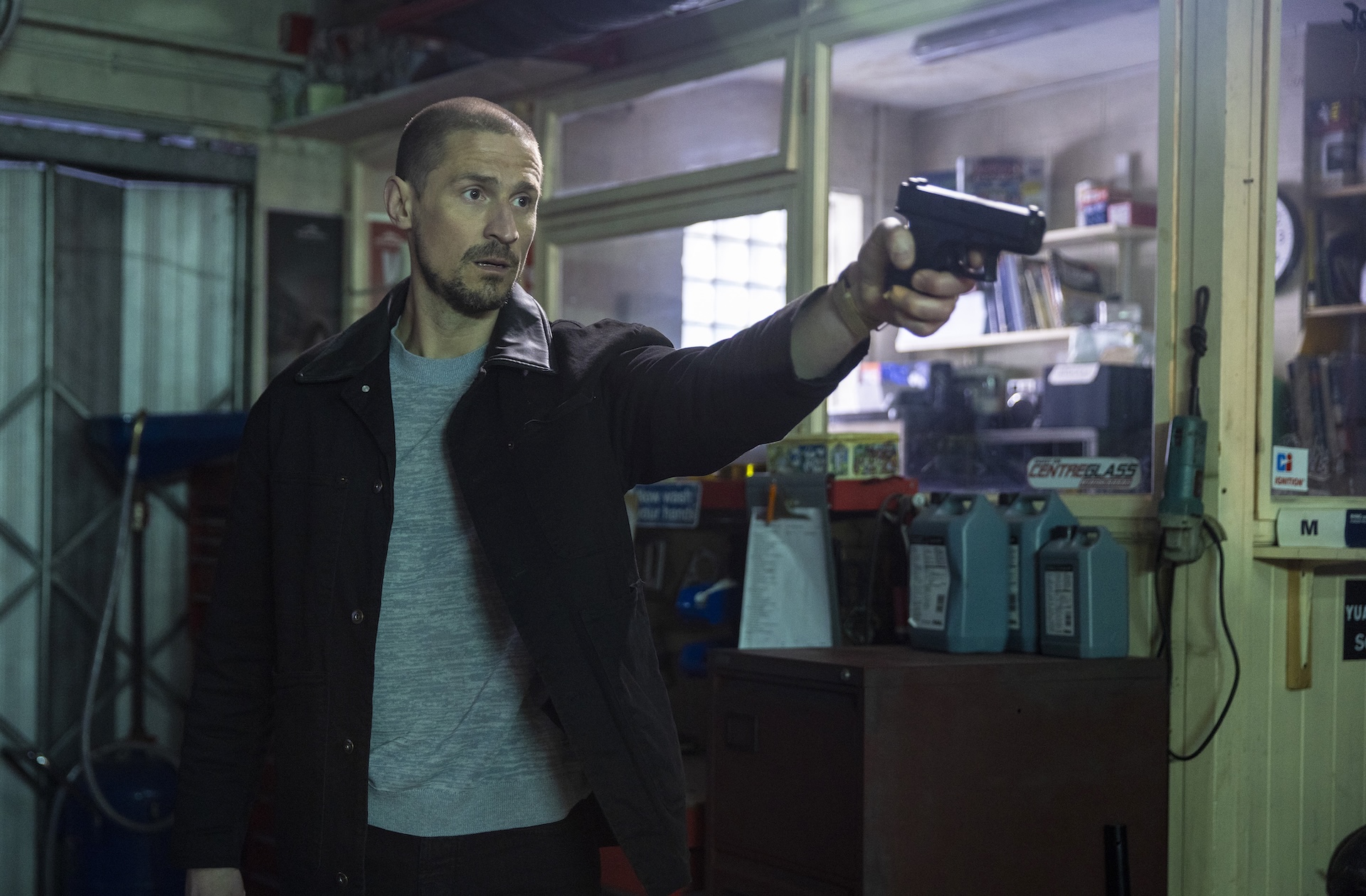Carl Webster pointing a gun in Coronation Street