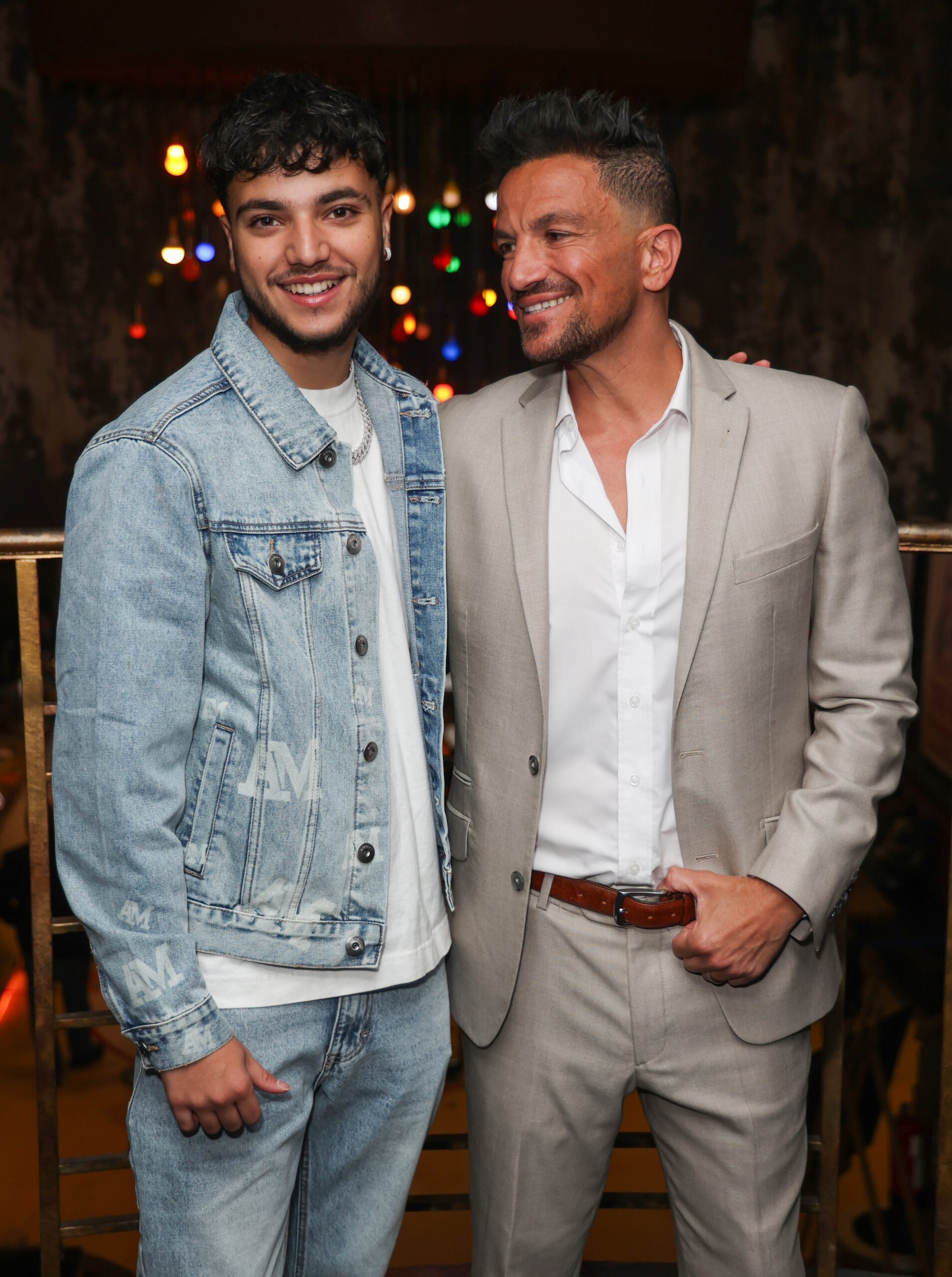 Junior and Peter Andre smiling at event