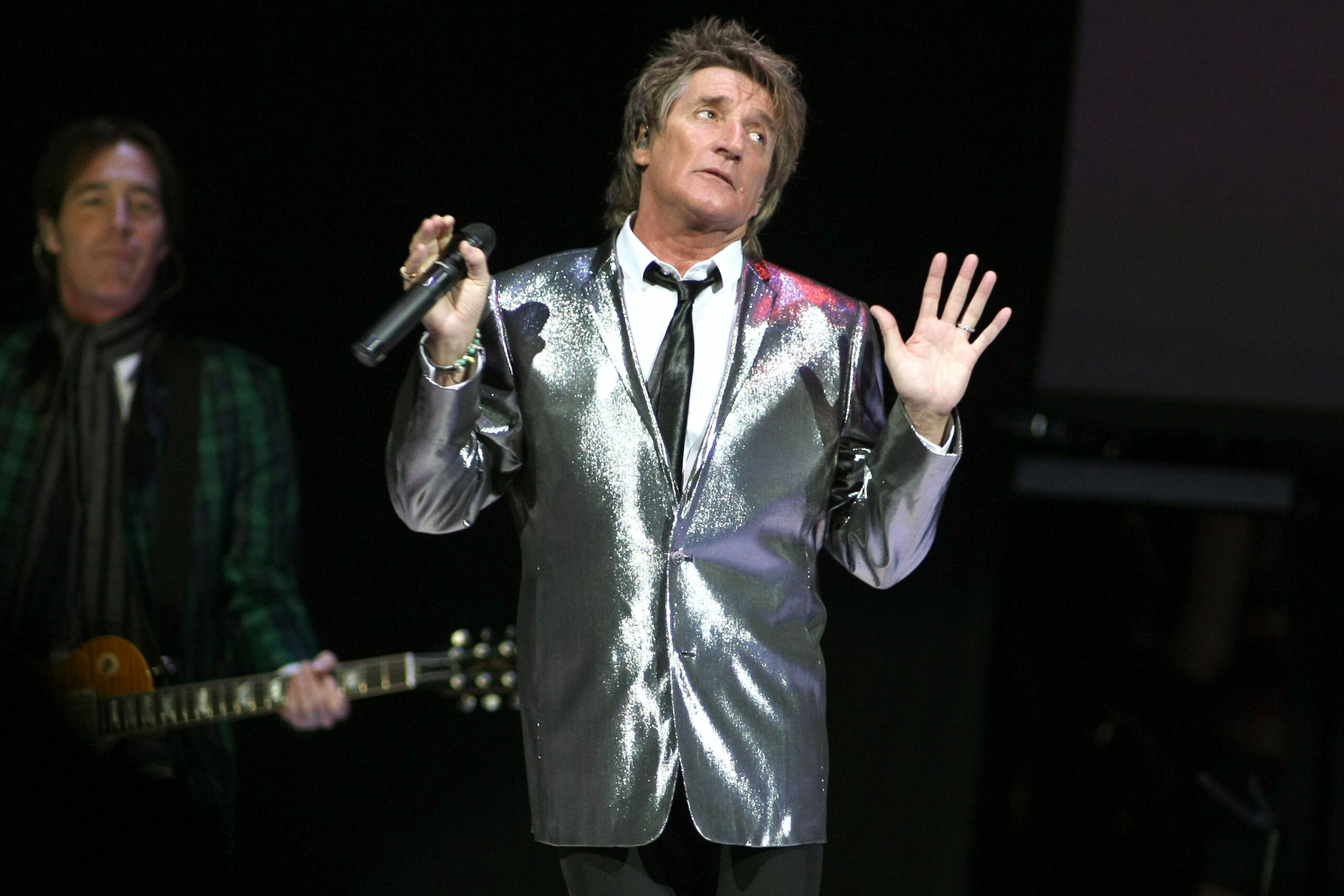 Rod Stewart holding his hands up