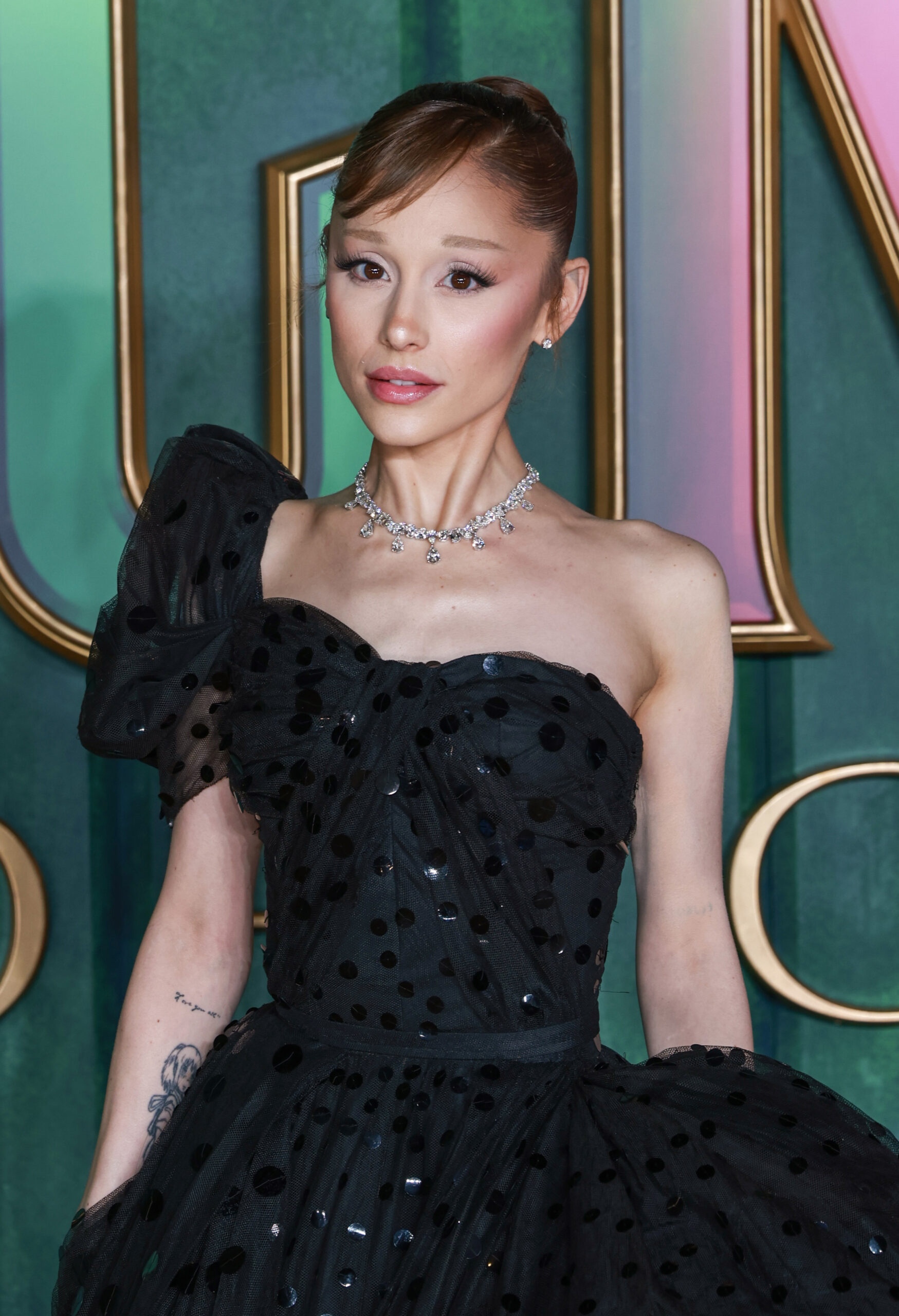 Araian Grande wearing a sparkling black dress with a serious expression on her face