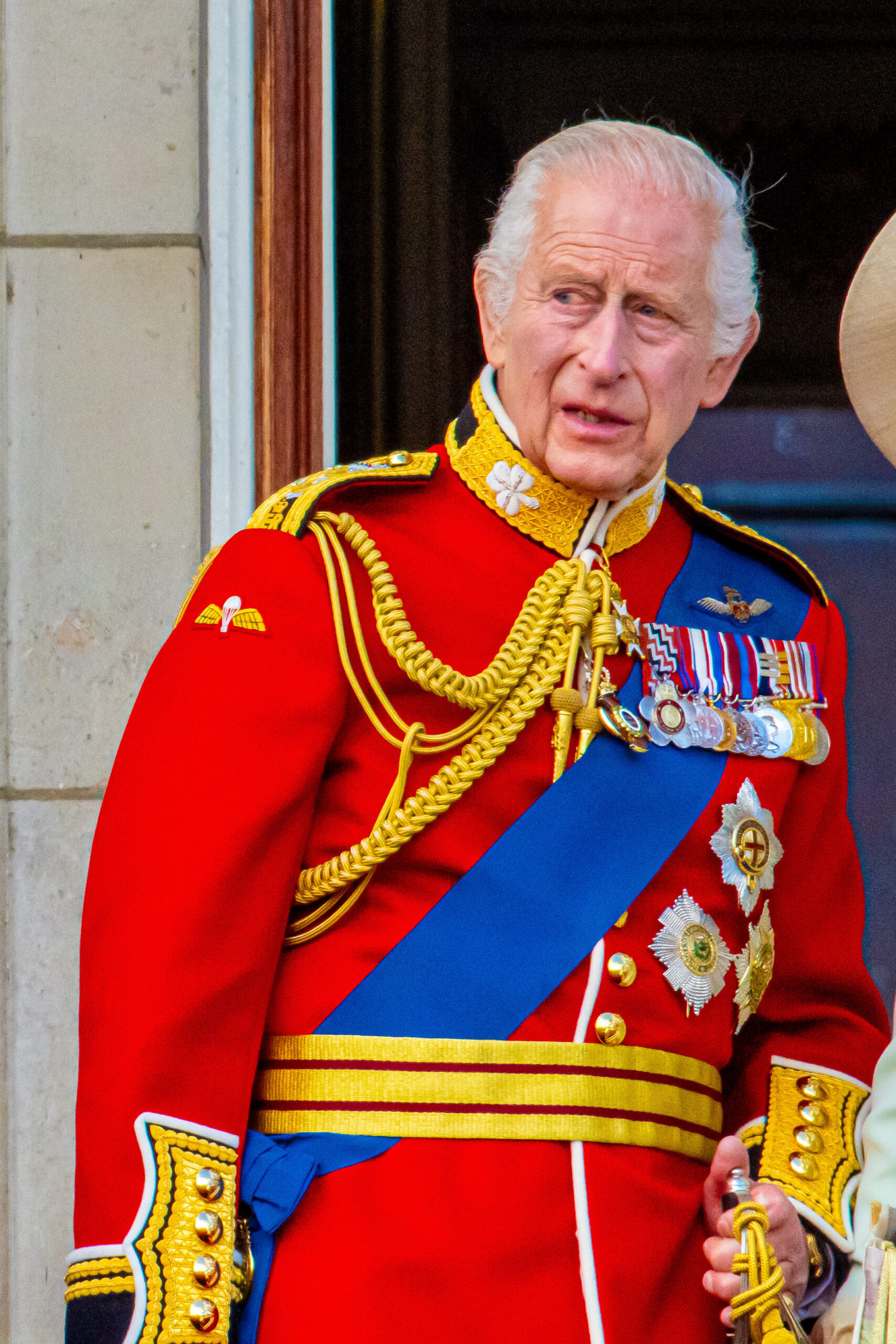 King Charles grimacing stood on the balcony at Trooping the Colour 2025