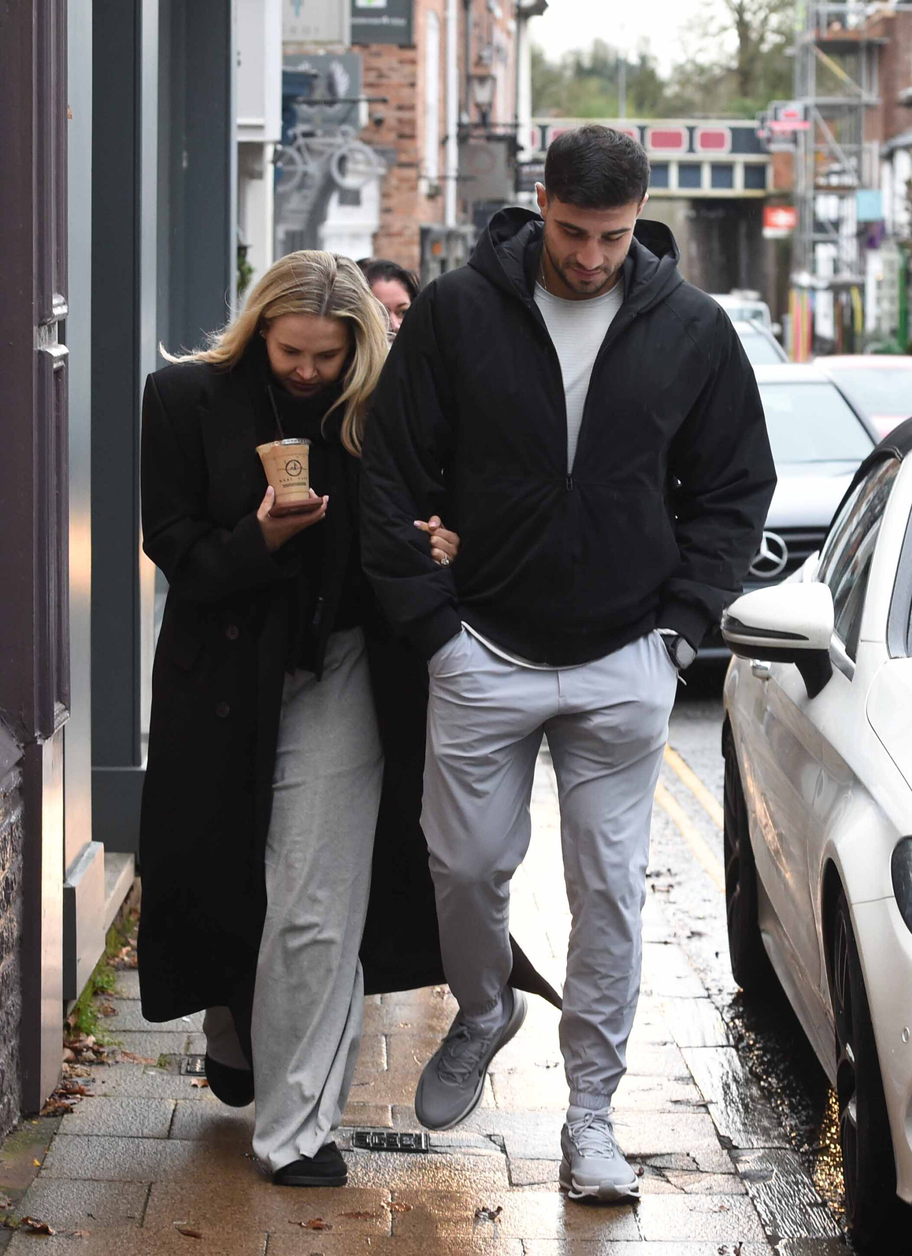 Molly-Mae and Tommy fury walking, Molly is looking down, wearing her engagement ring