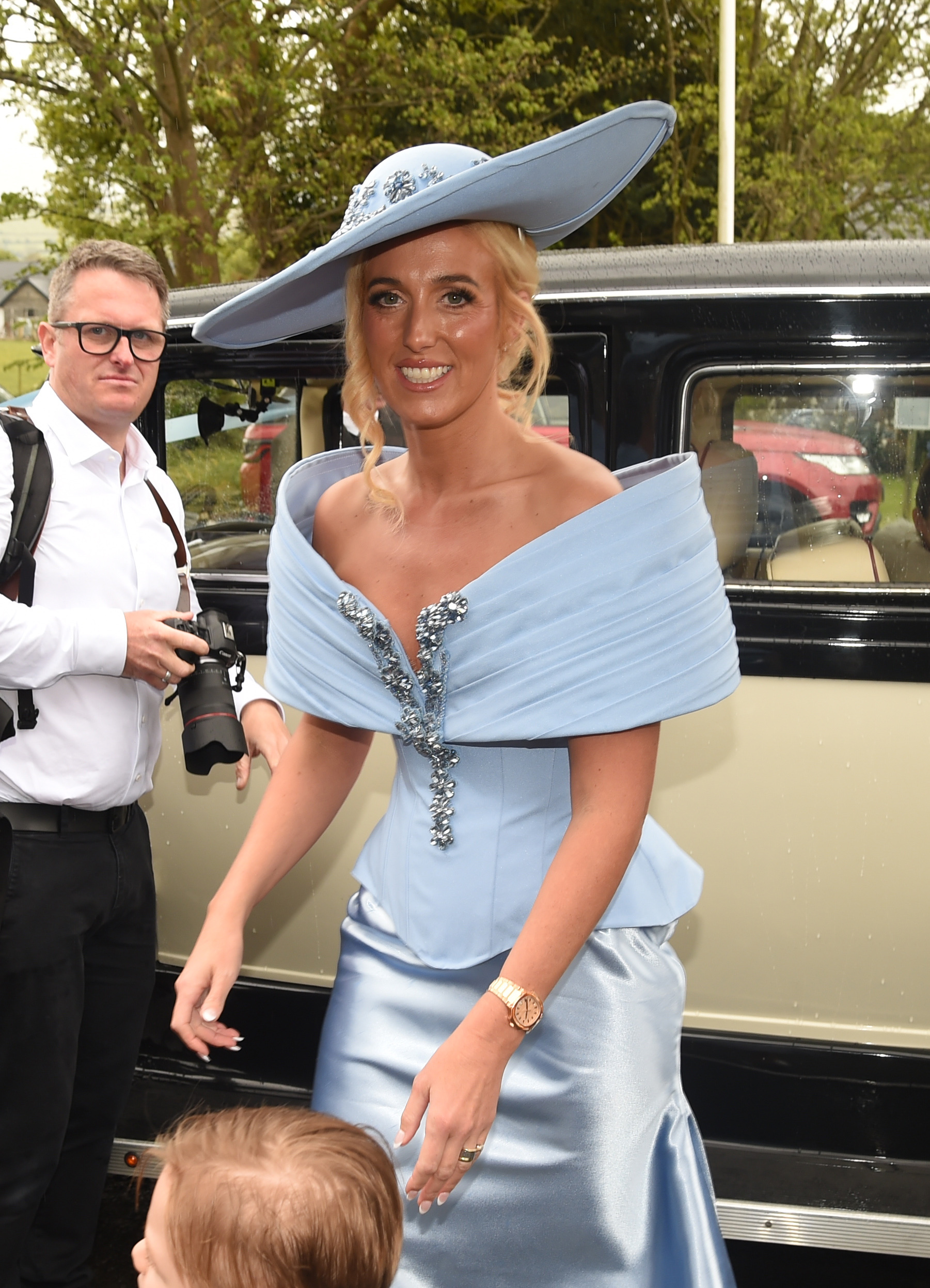 Paris Fury smiling wearing blue arriving at the wedding of her eldest daughter 