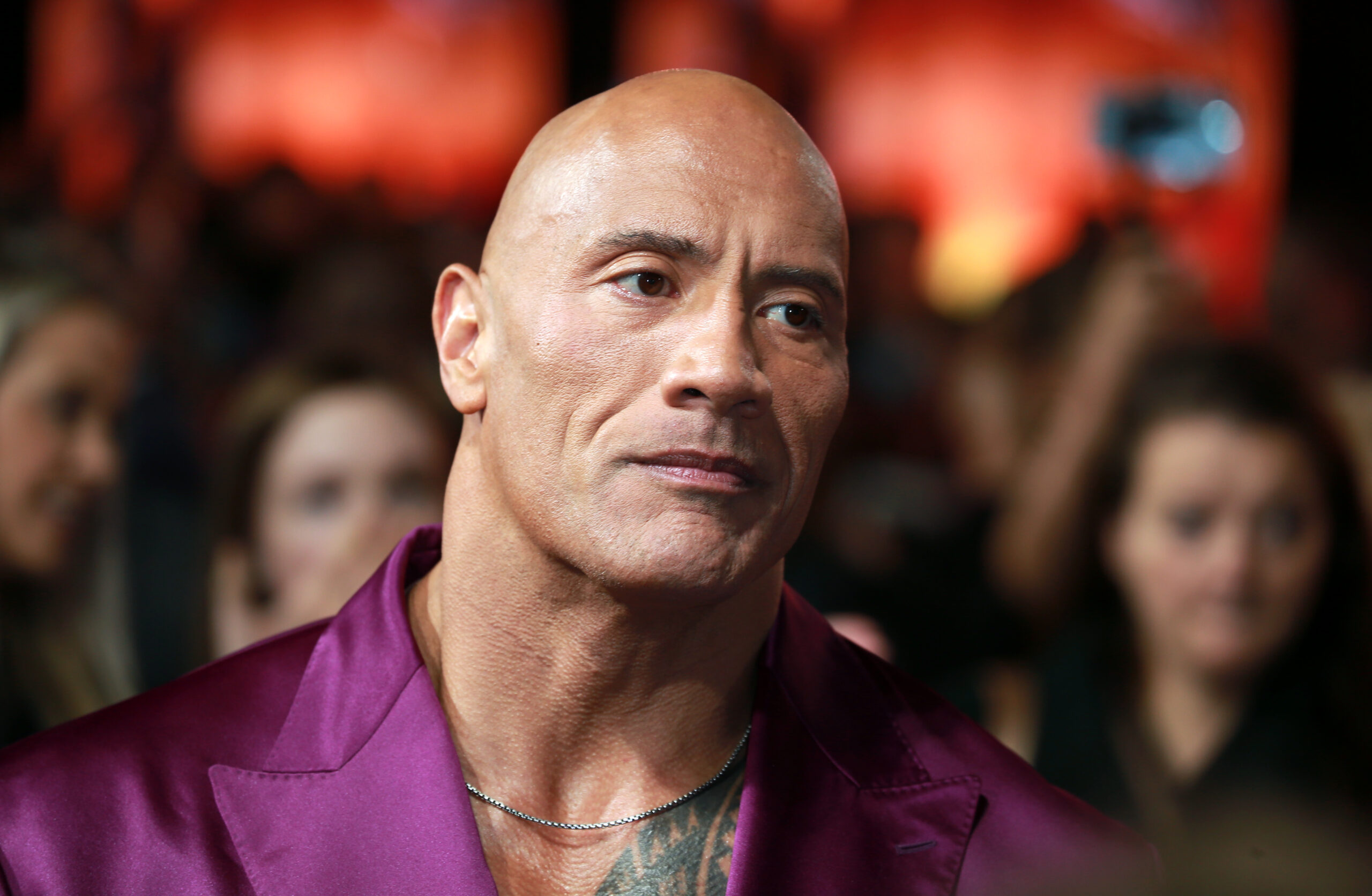 Dwayne Johnson frowning wearing a satin suit